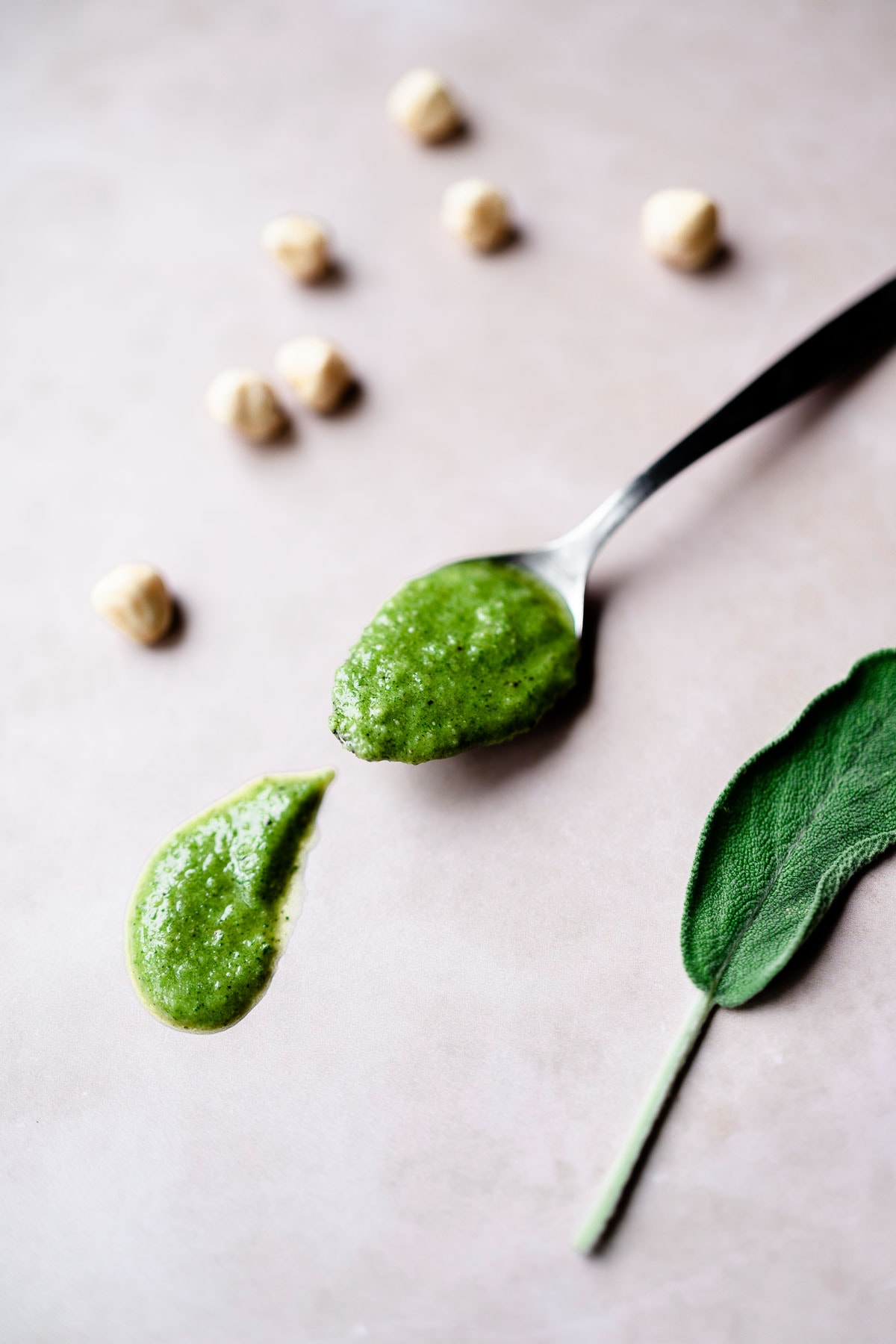 a silver spoon filled with green sage pesto