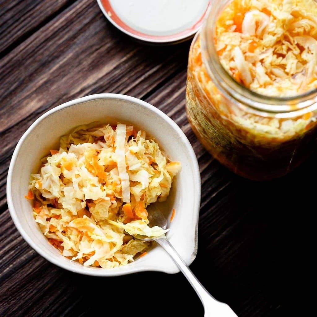 a white bowl filled with homemade pickled cabbage with carrots