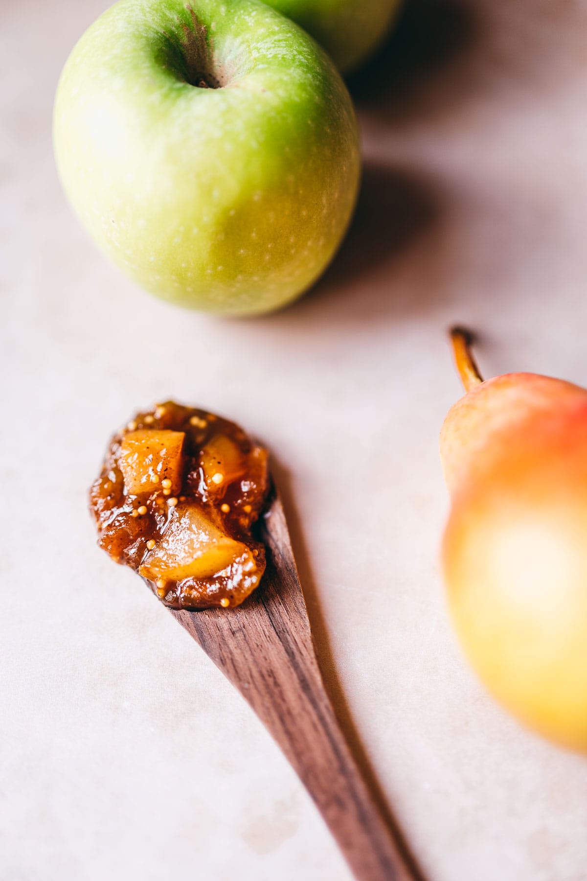 a wooden spoon topped with fresh apple pear chutney