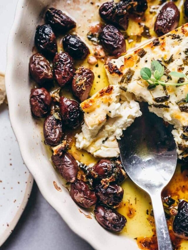 Feta and olives in a dish with a spoon.