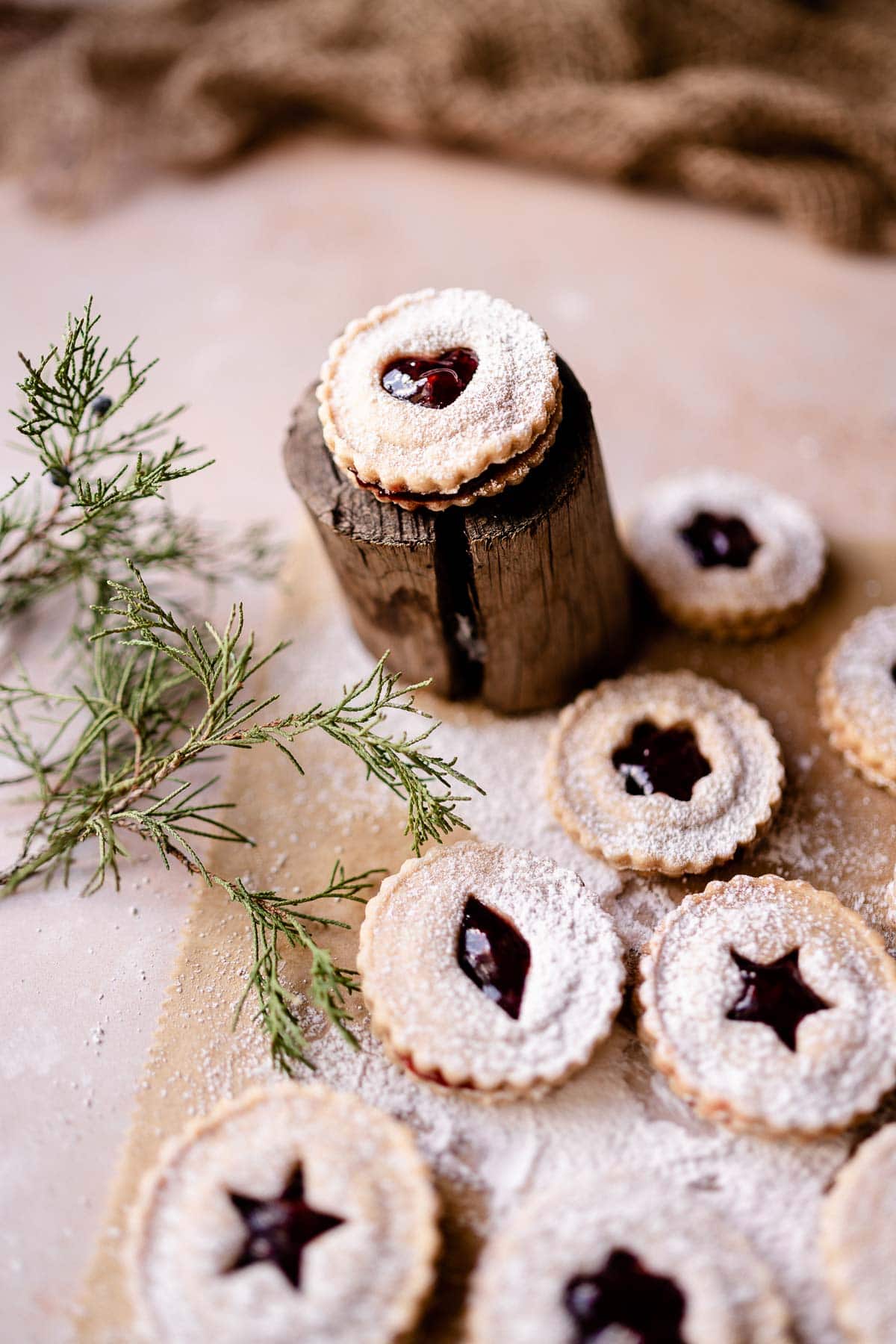 gluten free linzer cookies dusted with powdered sugar and filled with raspberry jam