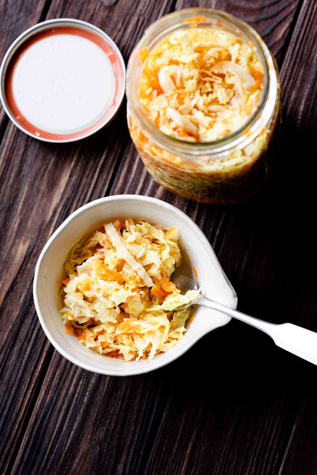 a fork stuck in a white ceramic bowl filled with pickled cabbage