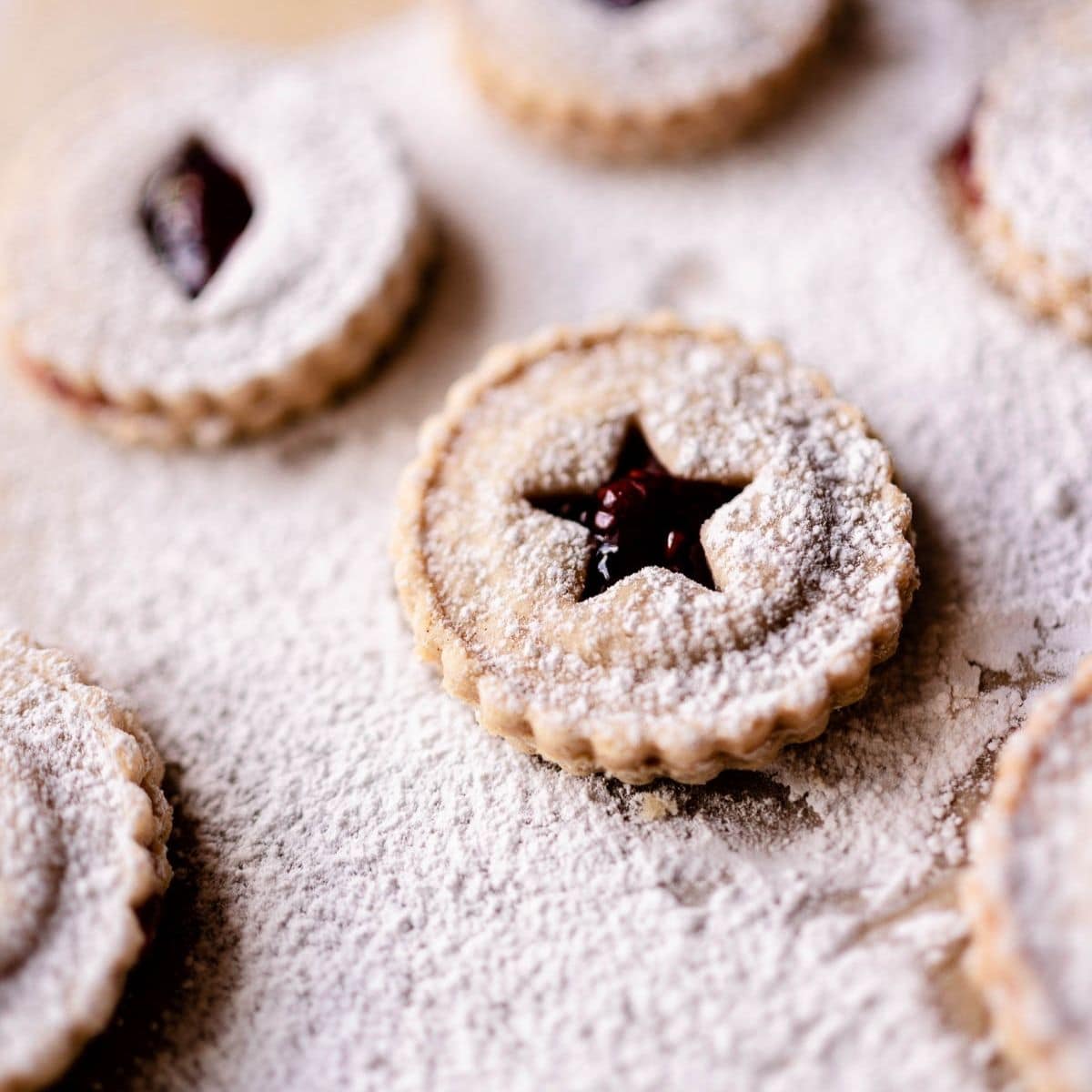 gluten free linzer cookies dusted with powdered sugar and cut out in star shapes