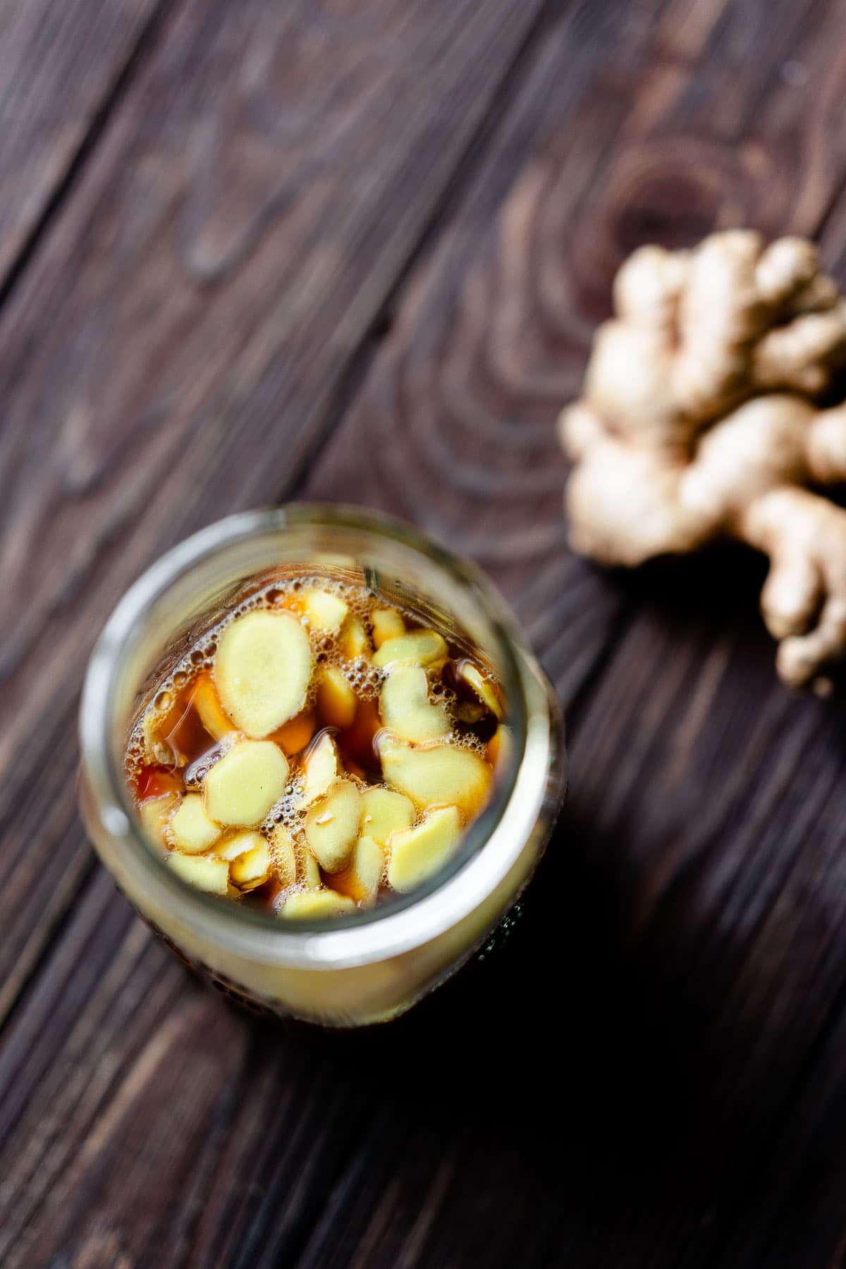 sweet pickled ginger floating in a large mason jar