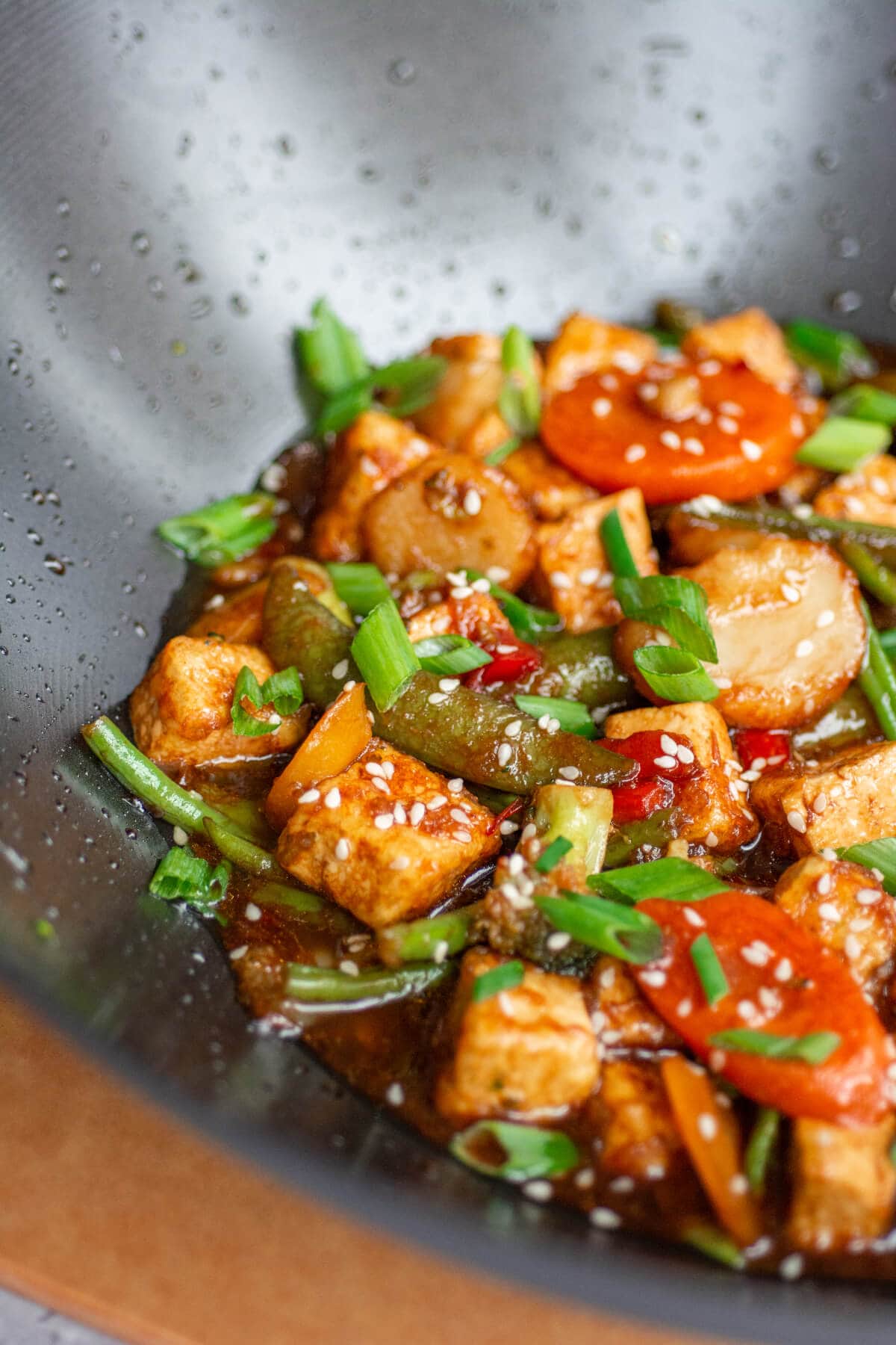 a wok filled with teriyaki tofu stir fry with vegetables