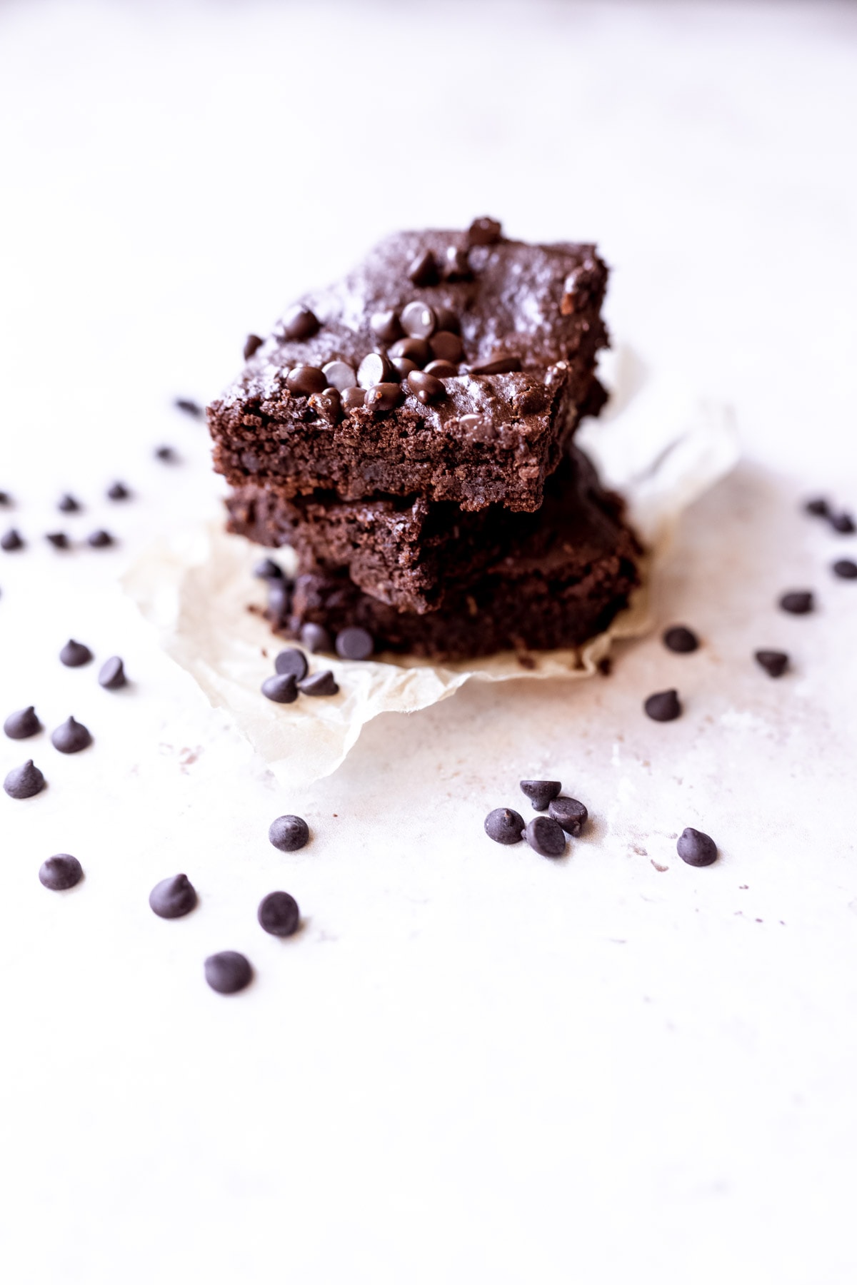 a stack of black bean brownies surrounded by small chocolate chips.