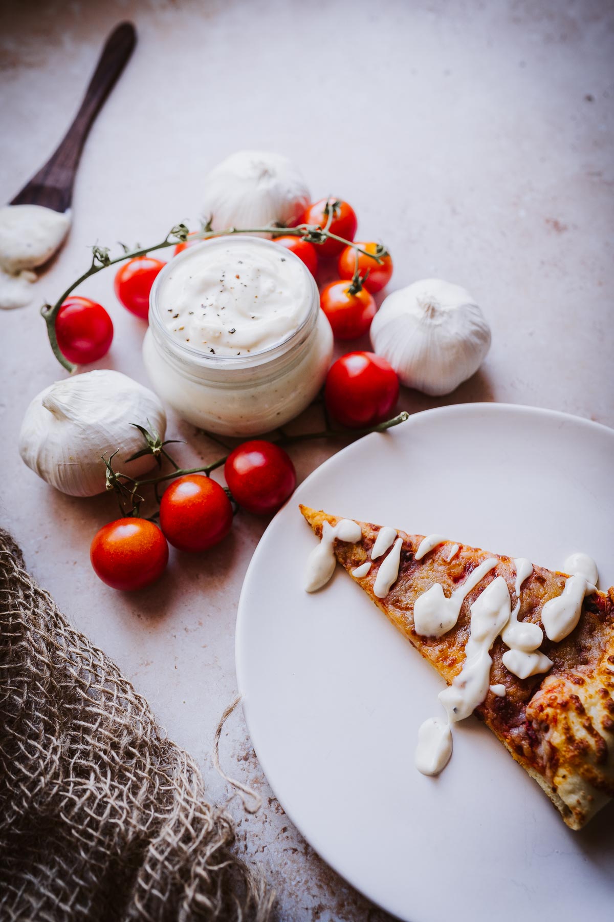 a slice of cheese pizza drizzled with homemade pizza aioli dipping sauce.