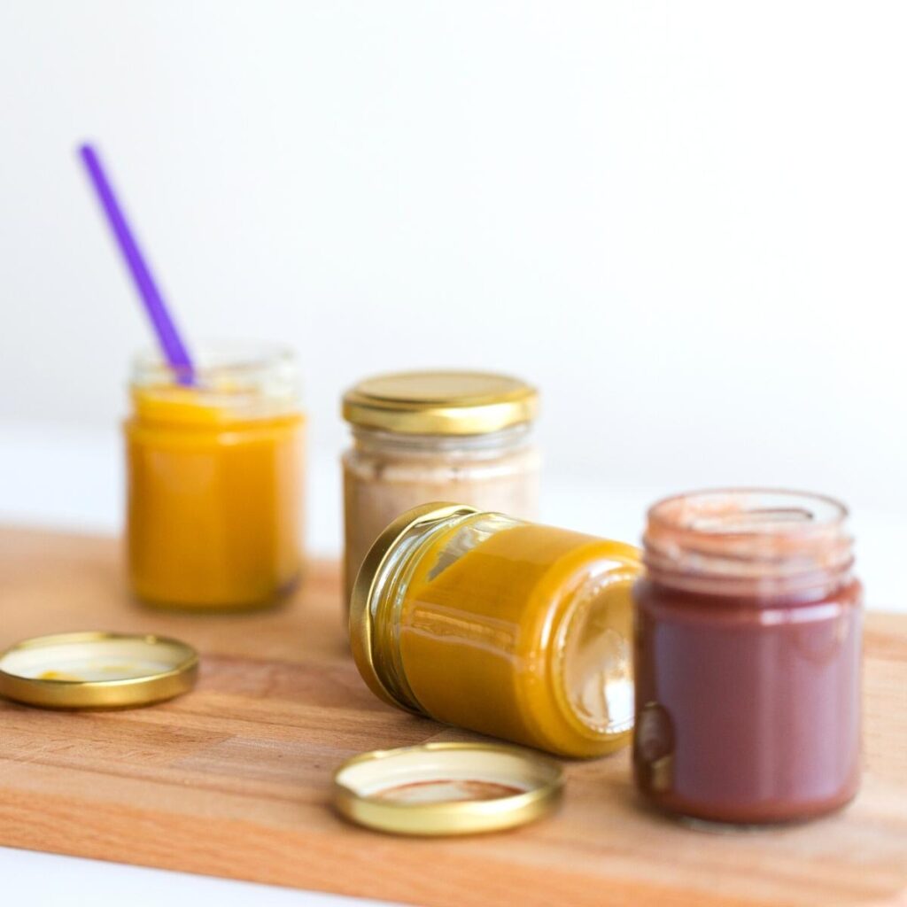 small glass jars of assorted fresh fruit purees.