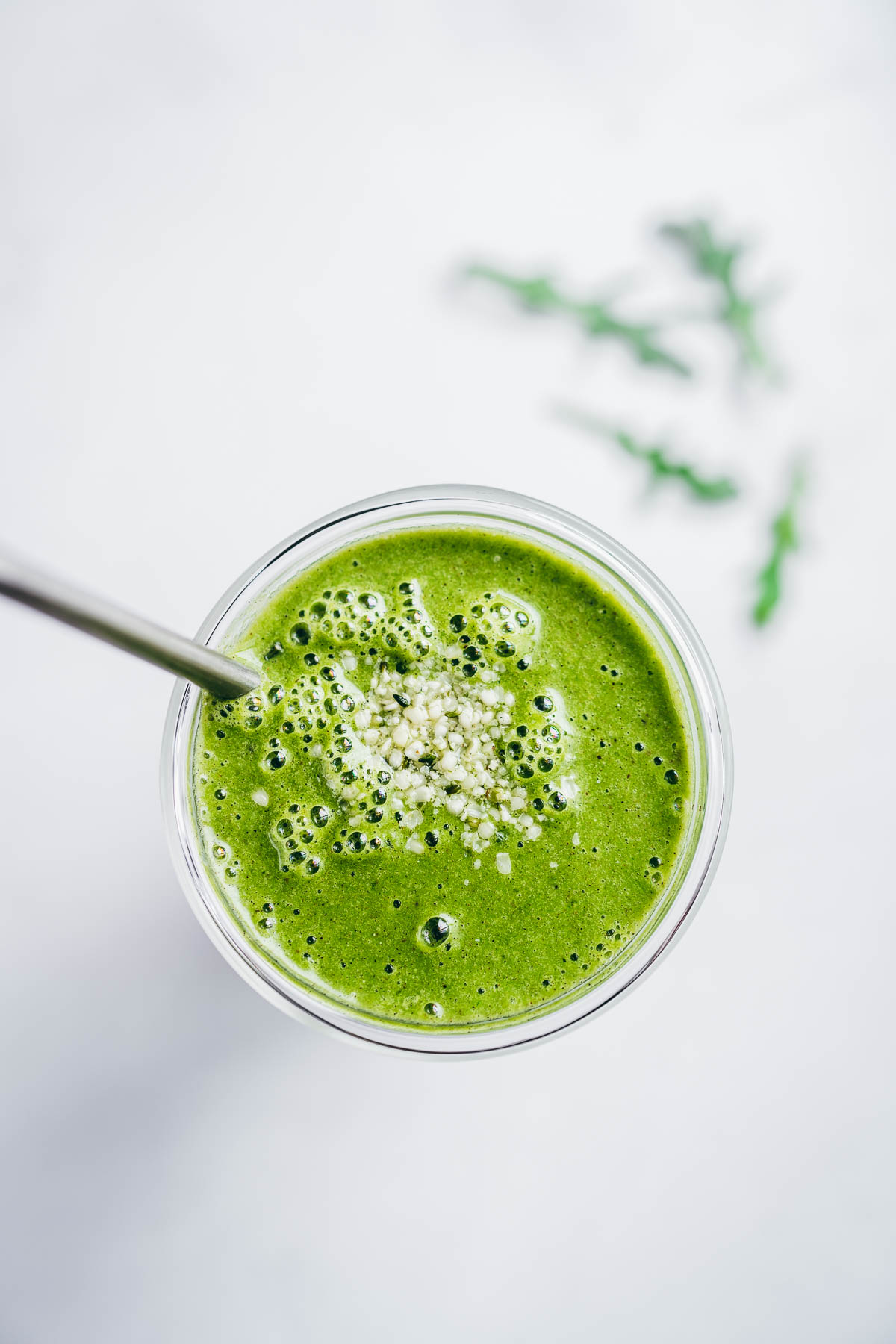 top view of a green smoothie made with arugula, pineapple, ginger, banana and spices.