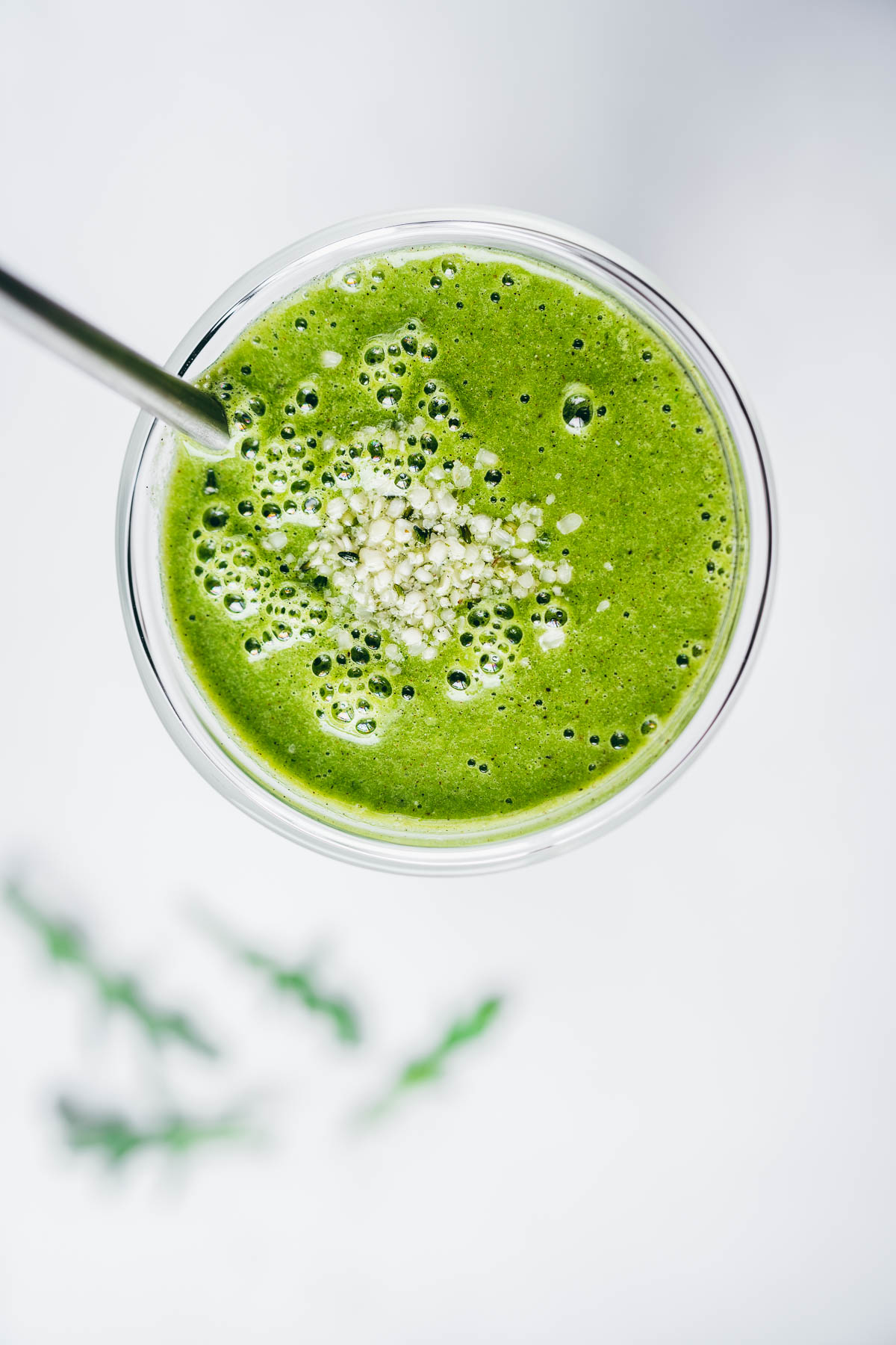 close top view of arugula smoothie topped with hemp hearts.