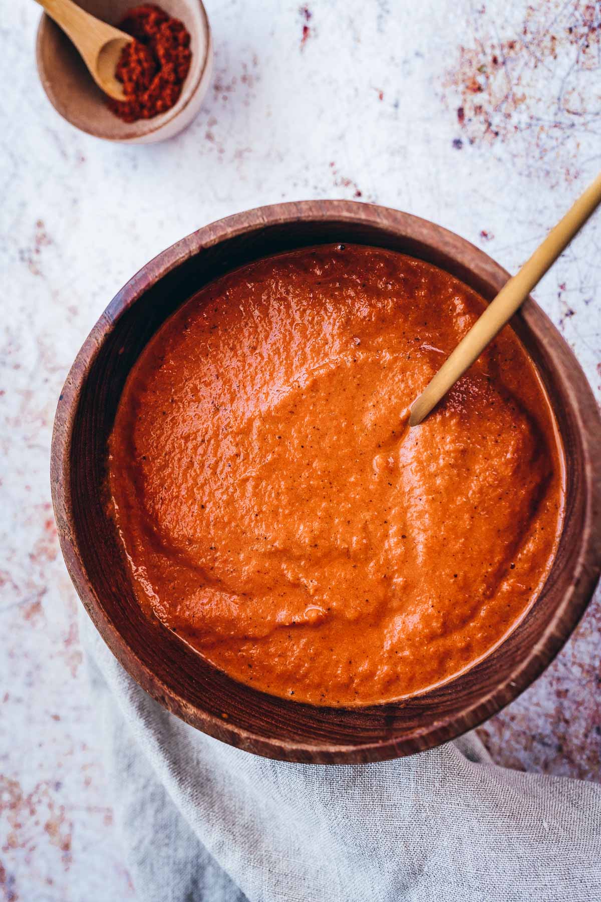 top view of red salsa bravas filling a wood bowl.