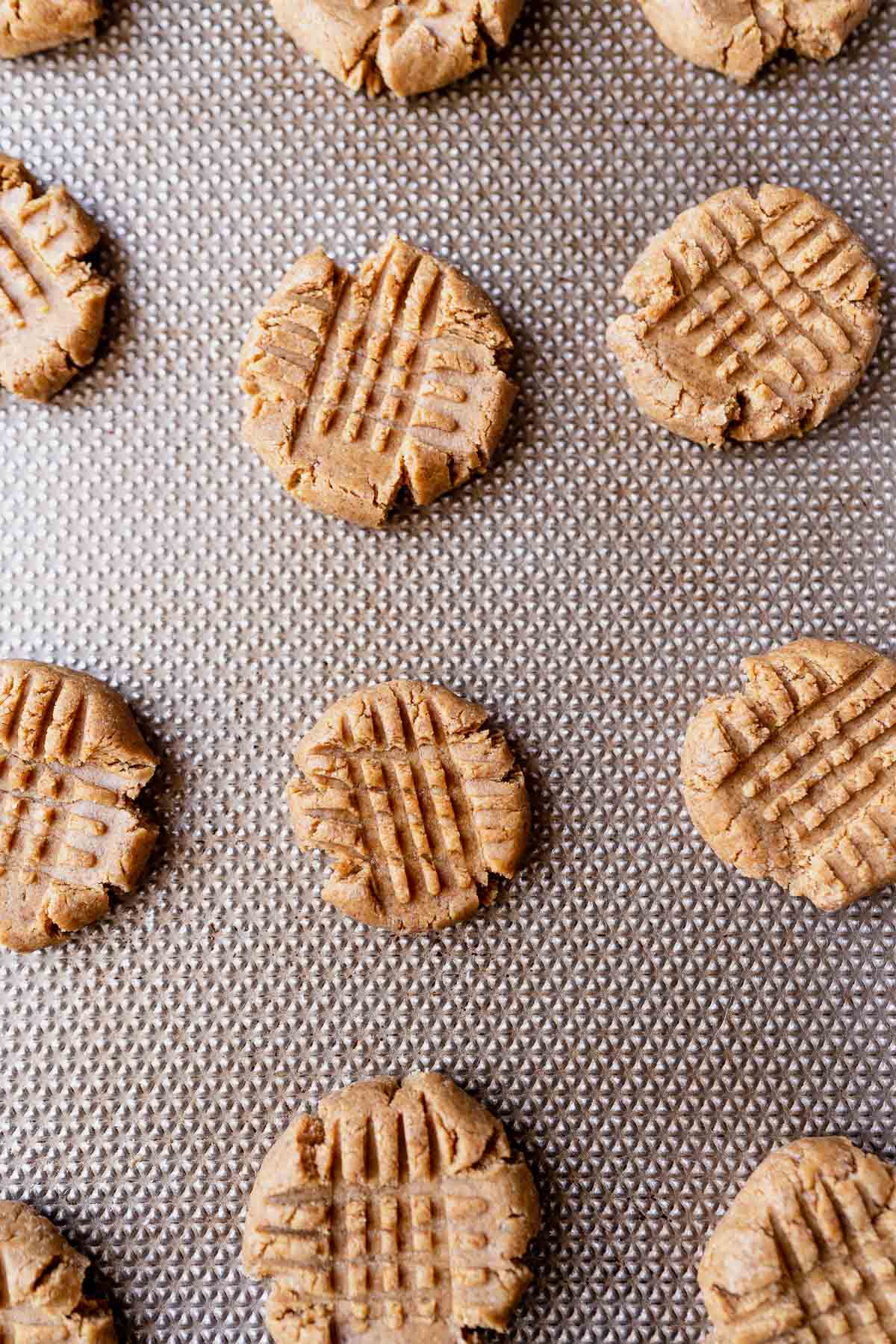 Top view of peanut butter cookie dough resting on a silver cookie sheet.