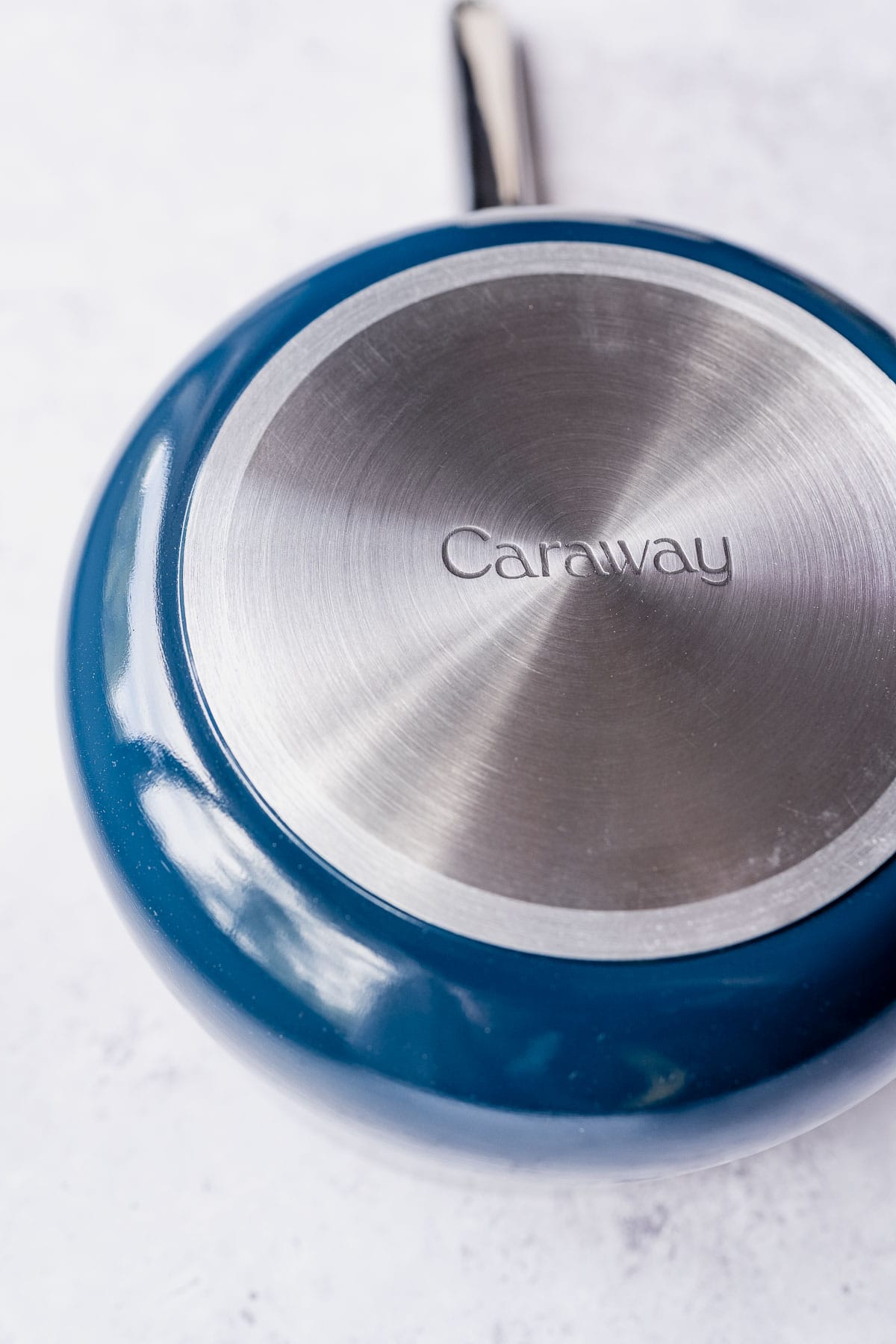 The silver bottom of a blue ceramic pot.