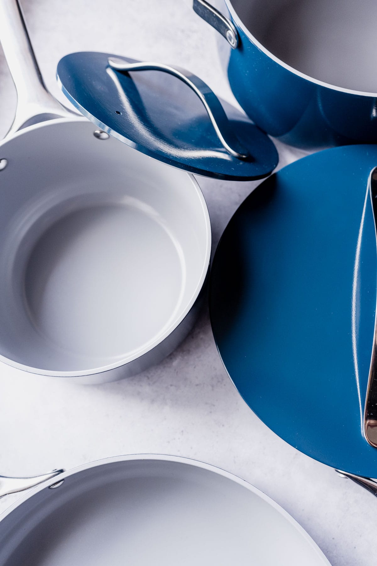 A blue ceramic cookware set resting on a gray table.