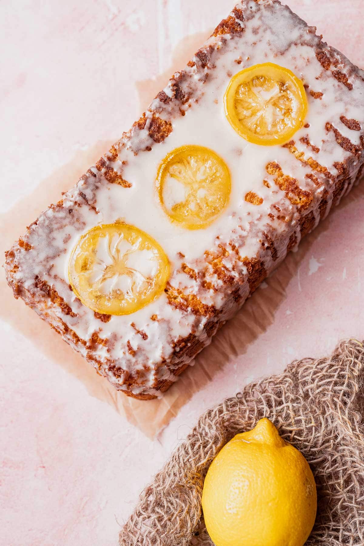 Top view of an iced loaf topped with fresh lemon slices.