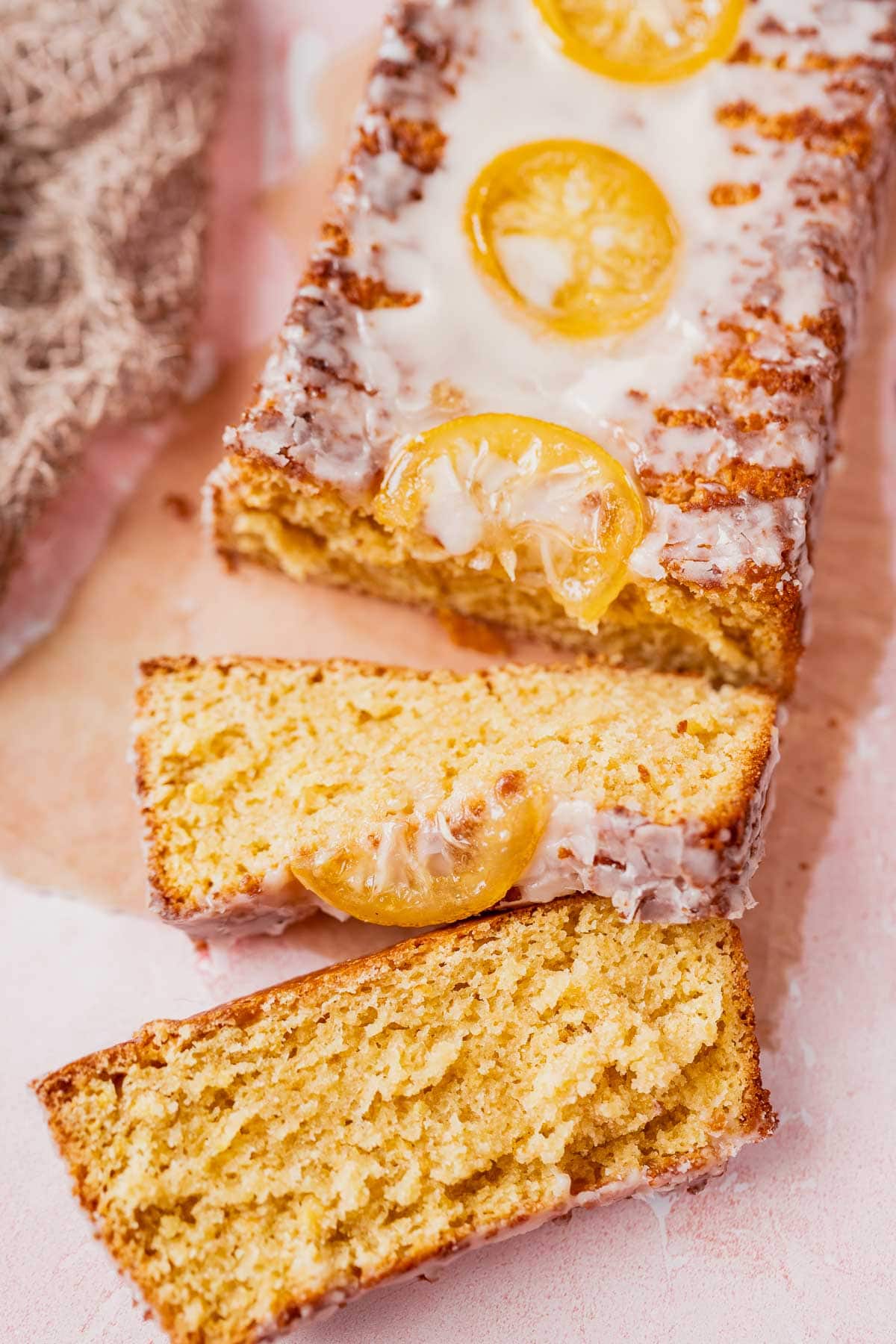 Slices of lemon cake rest on a light pink backdrop.