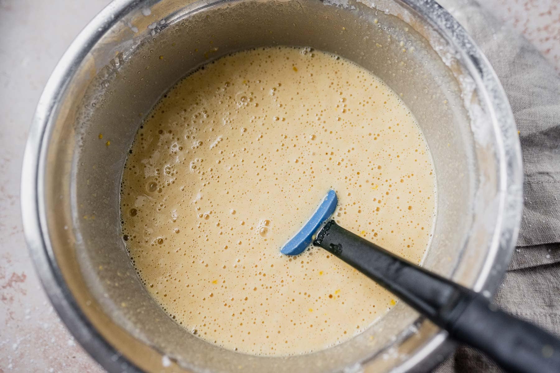 A mixing bowl filled with a light yellow batter.
