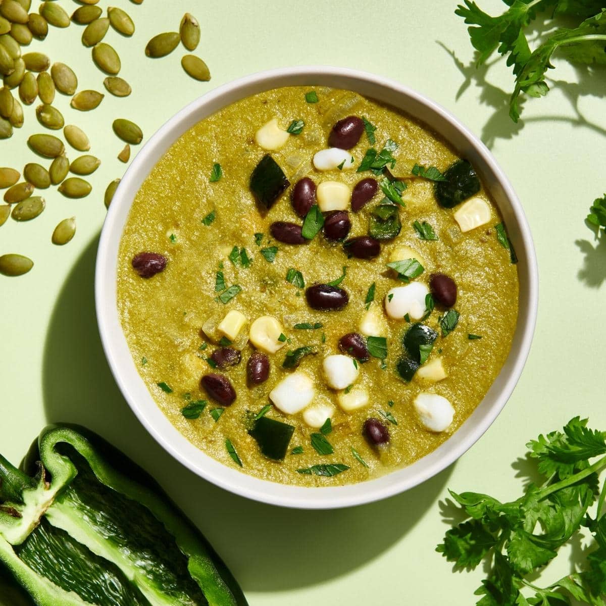 A white bowl filled with bright green soup.