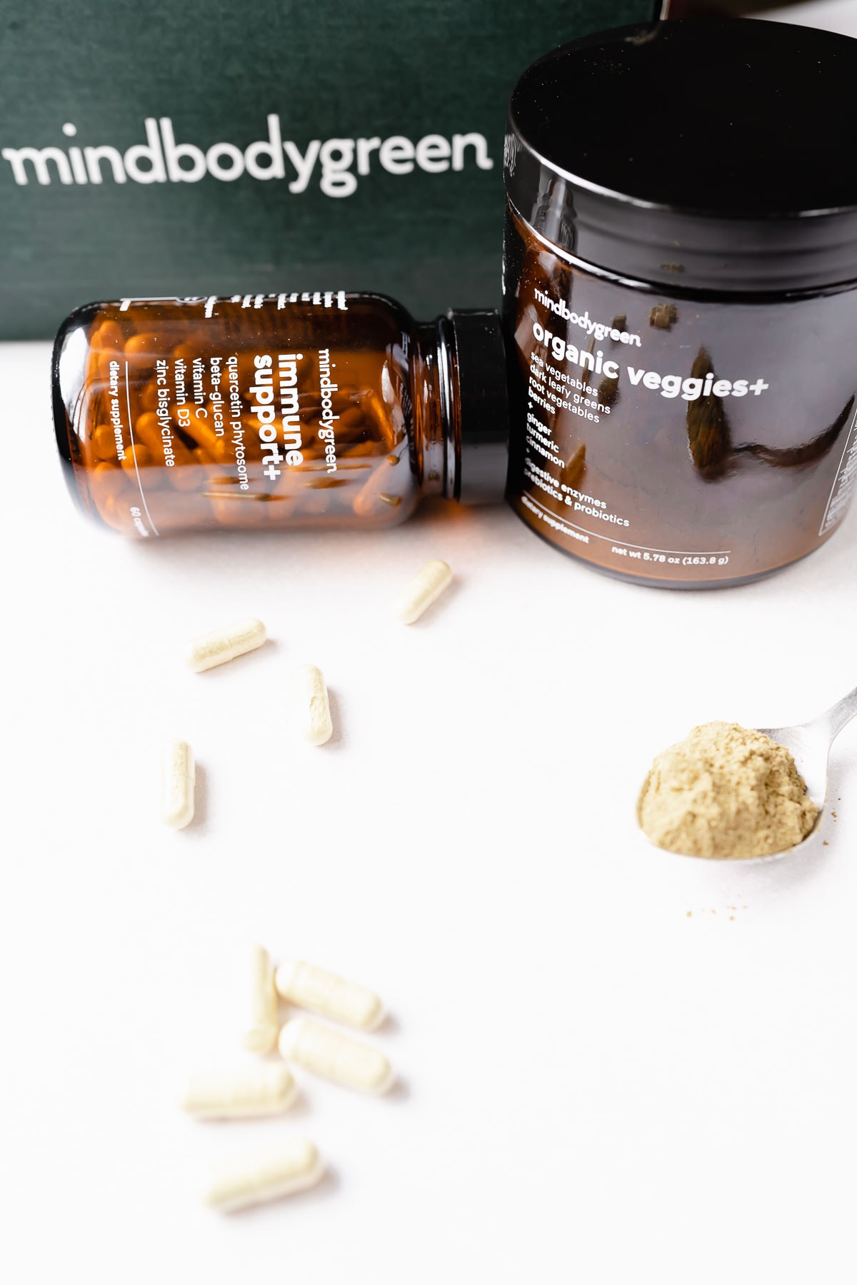 Capsules and powder rest next to dark brown containers.