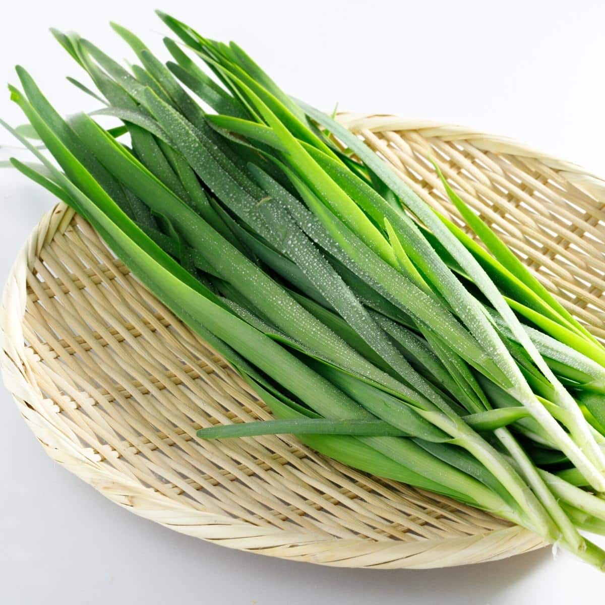 A wooden basket filled with Chinese chives.