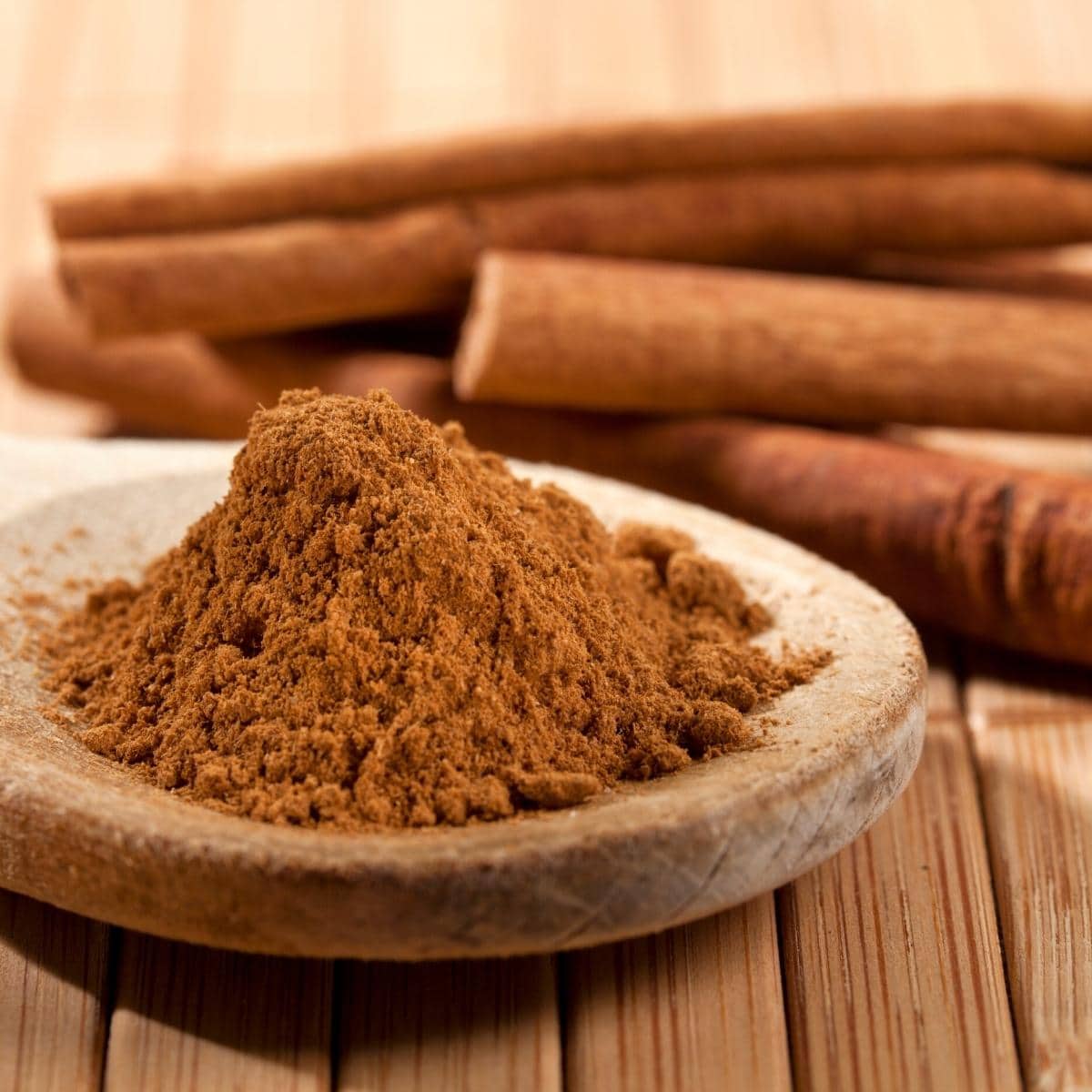 Ground cinnamon resting in a wooden dish.