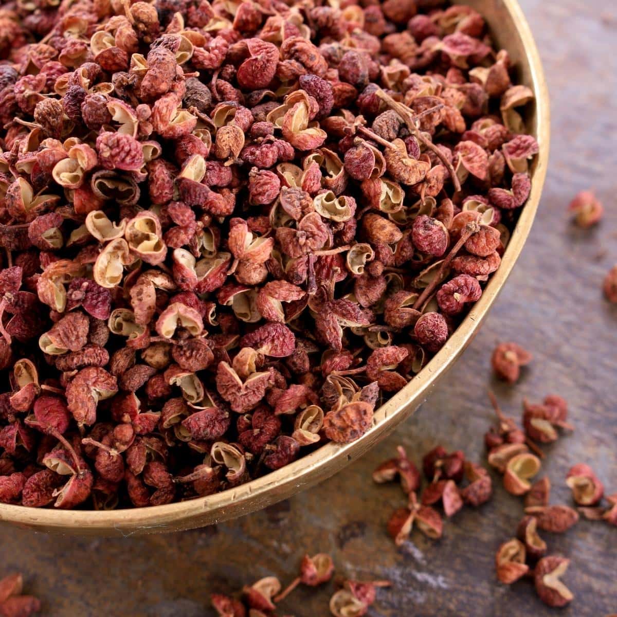 Sichuan peppercorns resting in a wooden bowl.