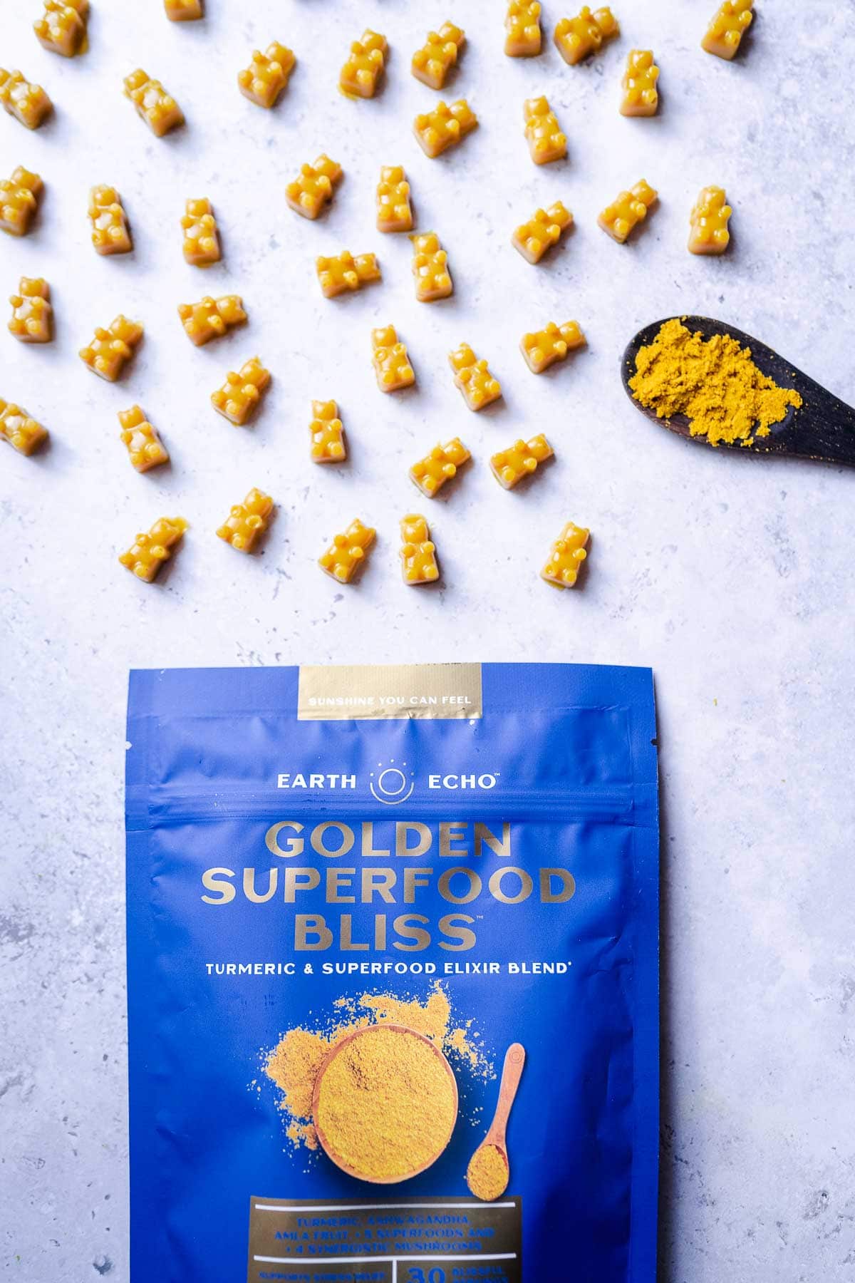 A blue Earth Echo Golden Superfood Bliss bag next to yellow gummy bears.