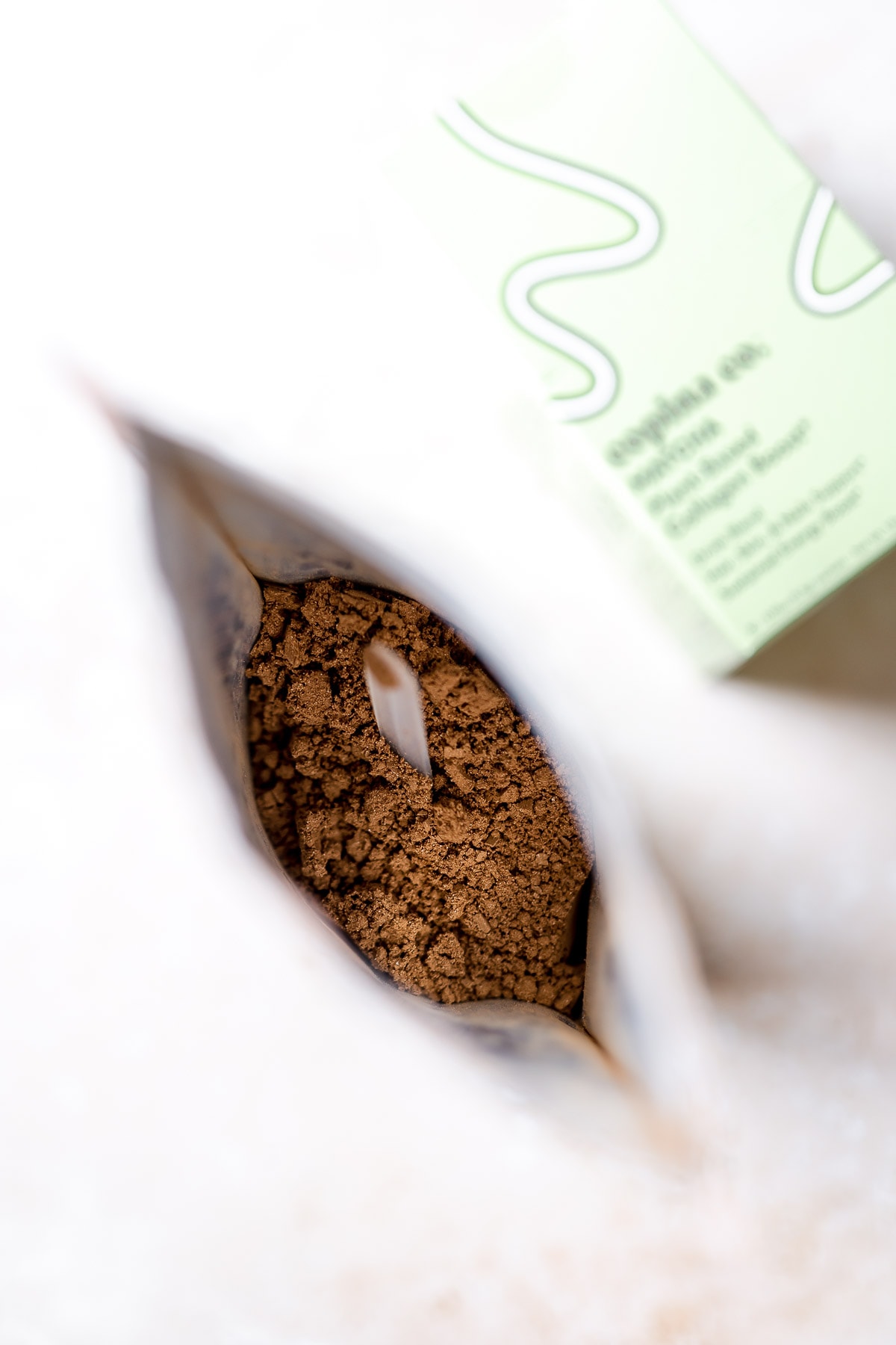 An open bag filled with a brown cacao powder.