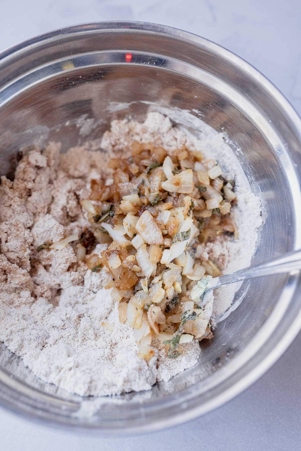 A silver mixing bowl filled with a variety of ingredients.