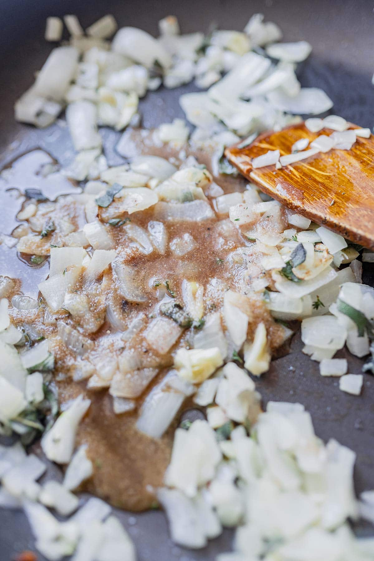 Chopped onions, herbs and sauce in a skillet.