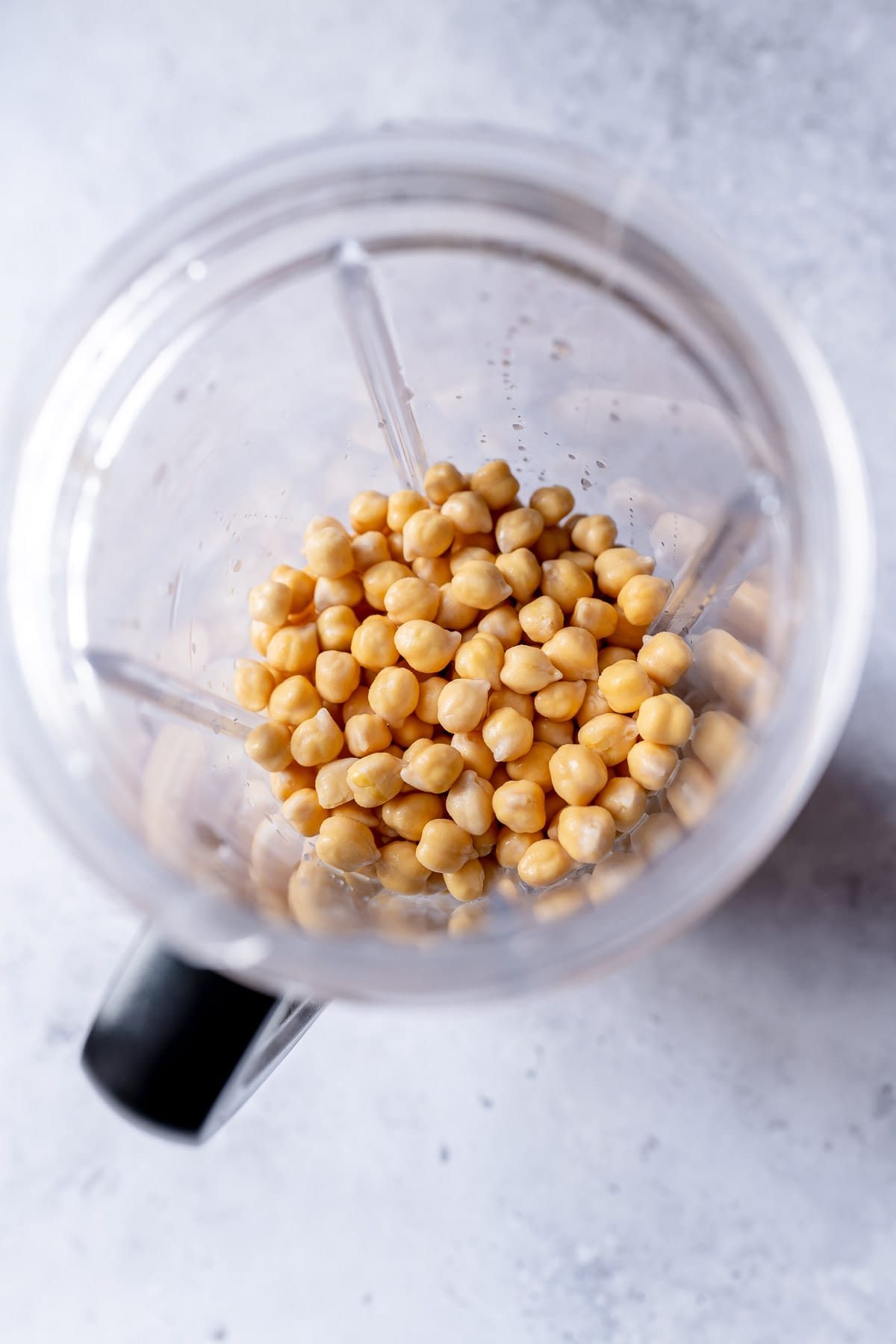 A blender container filled with garbanzo beans.