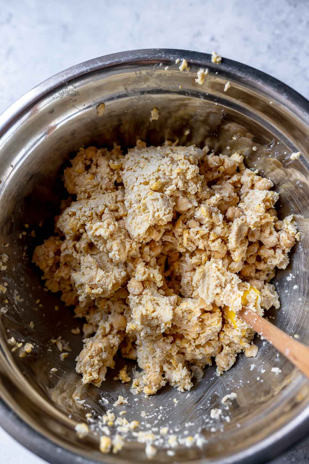 A silver mixing bowl filled with blended chickpeas.