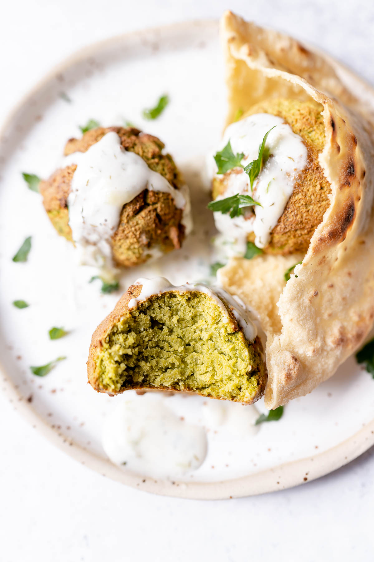 Close shot of a falafel ball with a bite taken out of it.