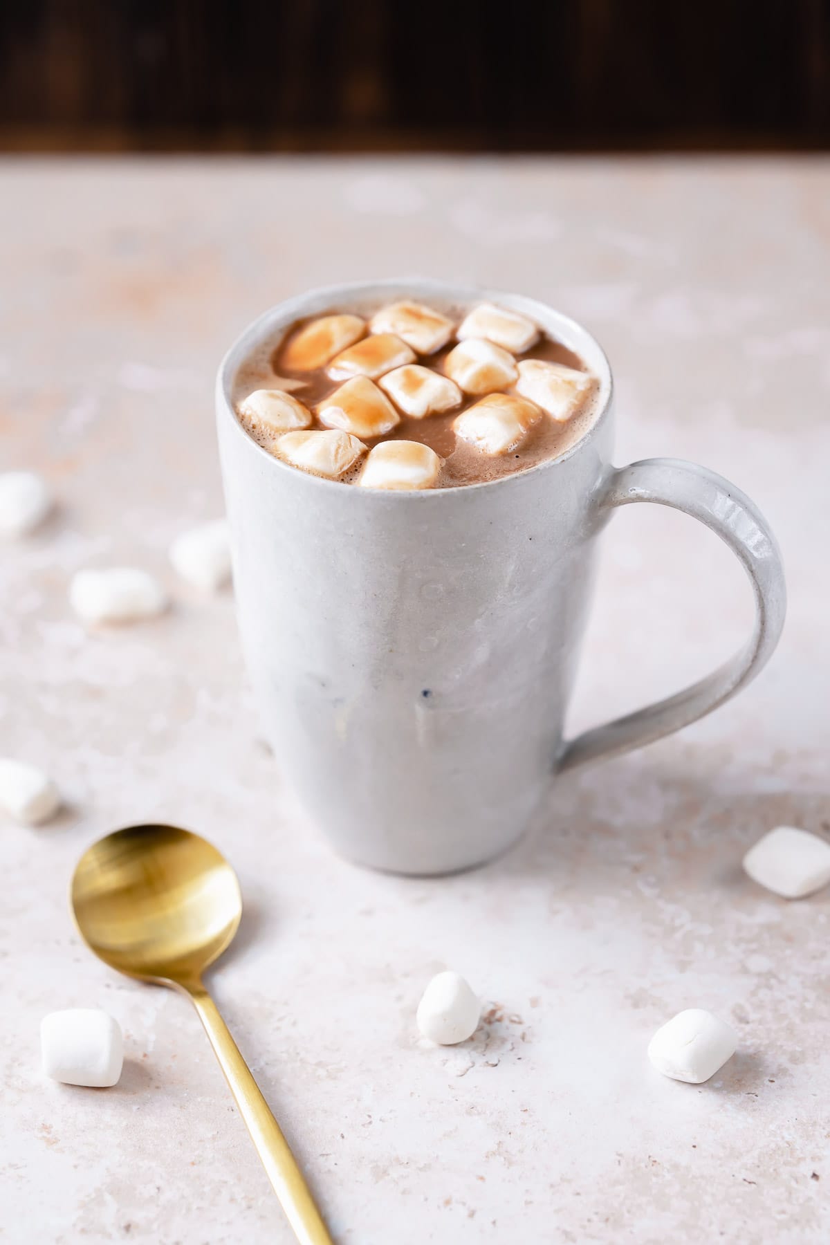 Close shot of a white mug filled with hot cocoa and marshmallows.