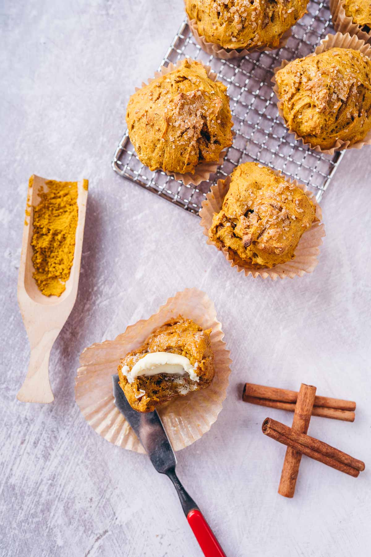 A gold muffin sliced in half and topped with melting butter.