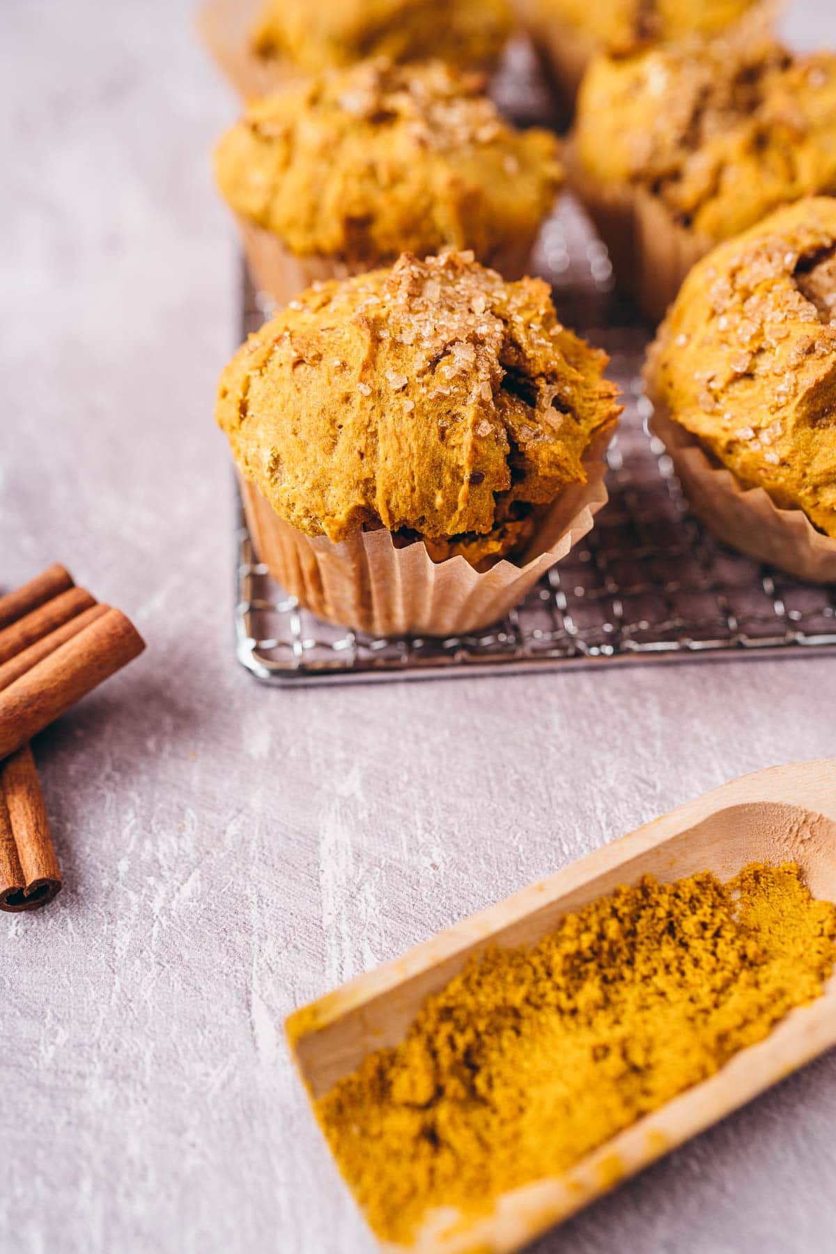 A close shot of a gold muffin topped with crunchy sugar crystals.