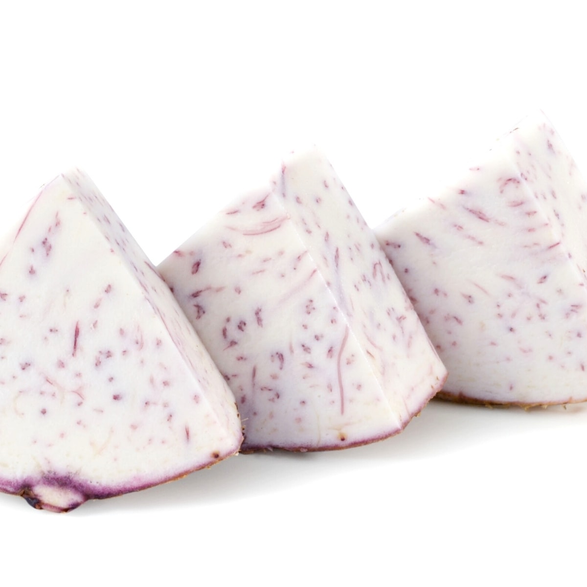 Cut taro root slices resting on a white table.