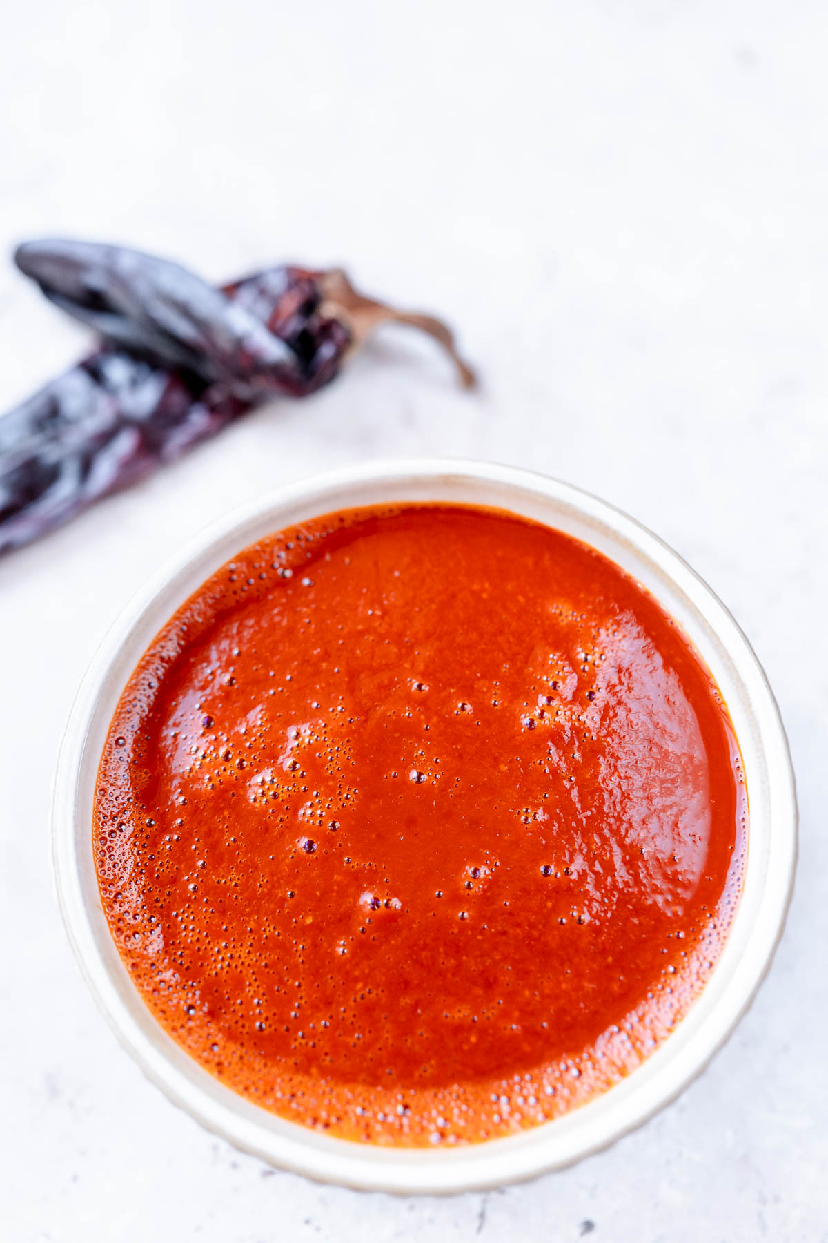 Top view of a white bowl filled with a vibrant red sauce.