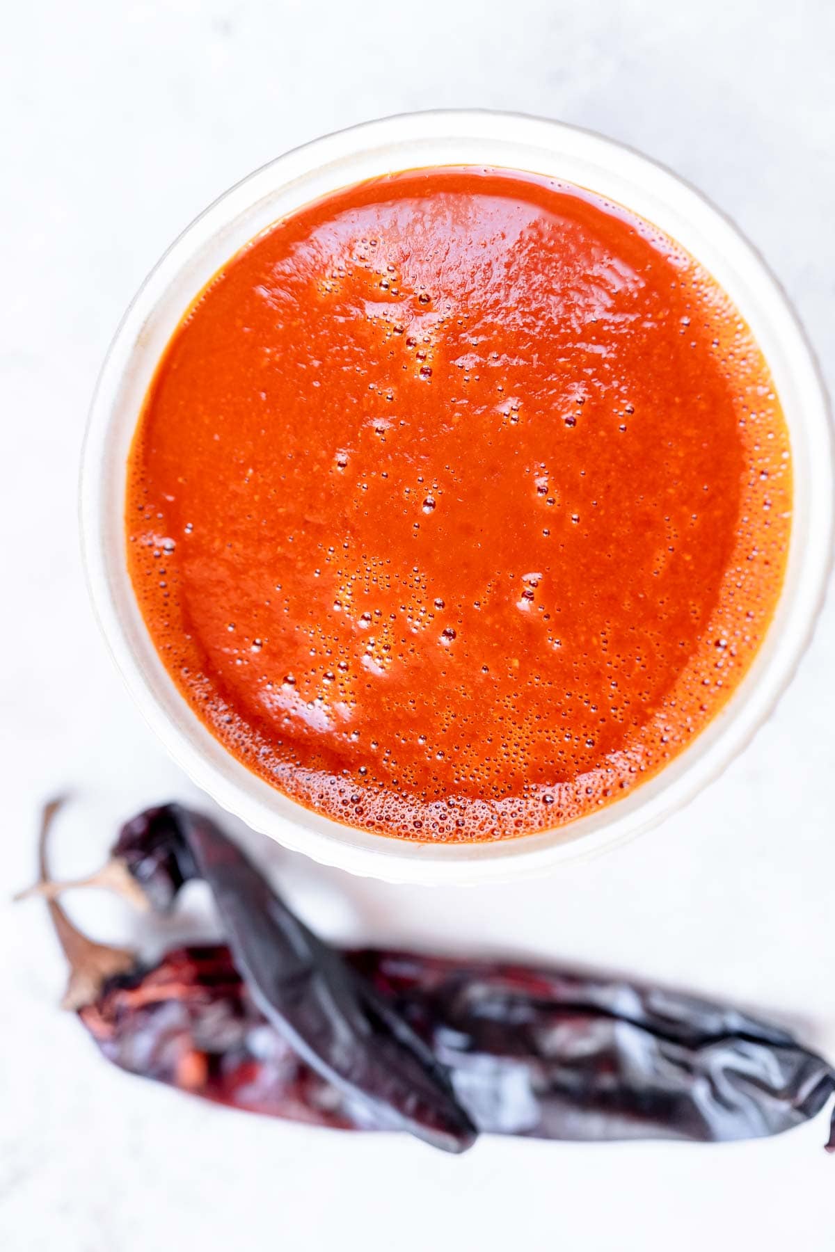 Top view of a white bowl filled with a red sauce.