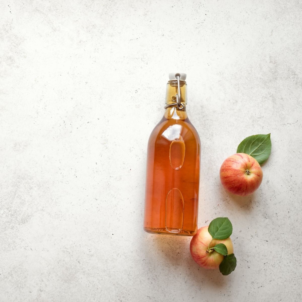 A clear glass bottle of apple cider vinegar.