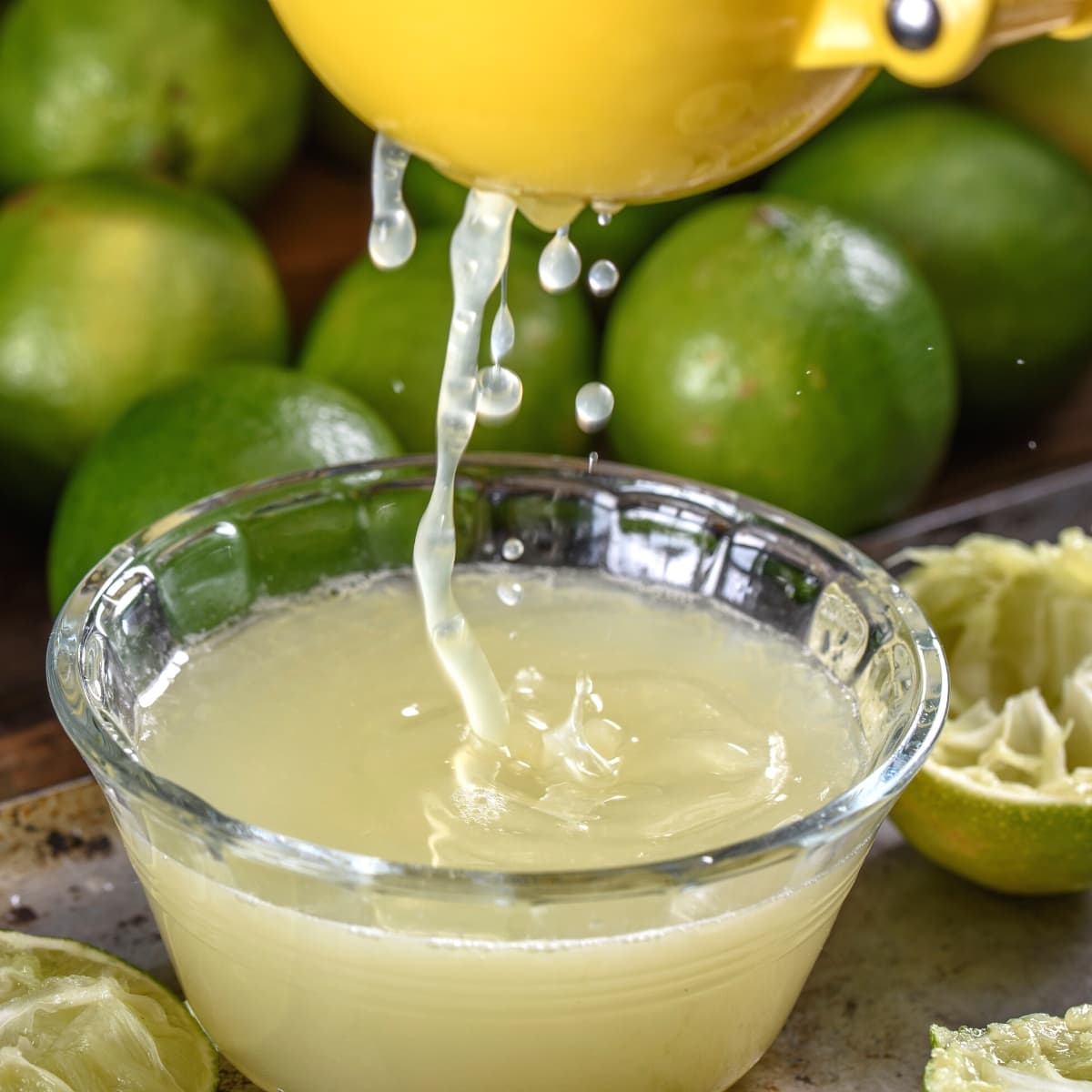 A small clear glass bowl of freshly squeezed lime juice.