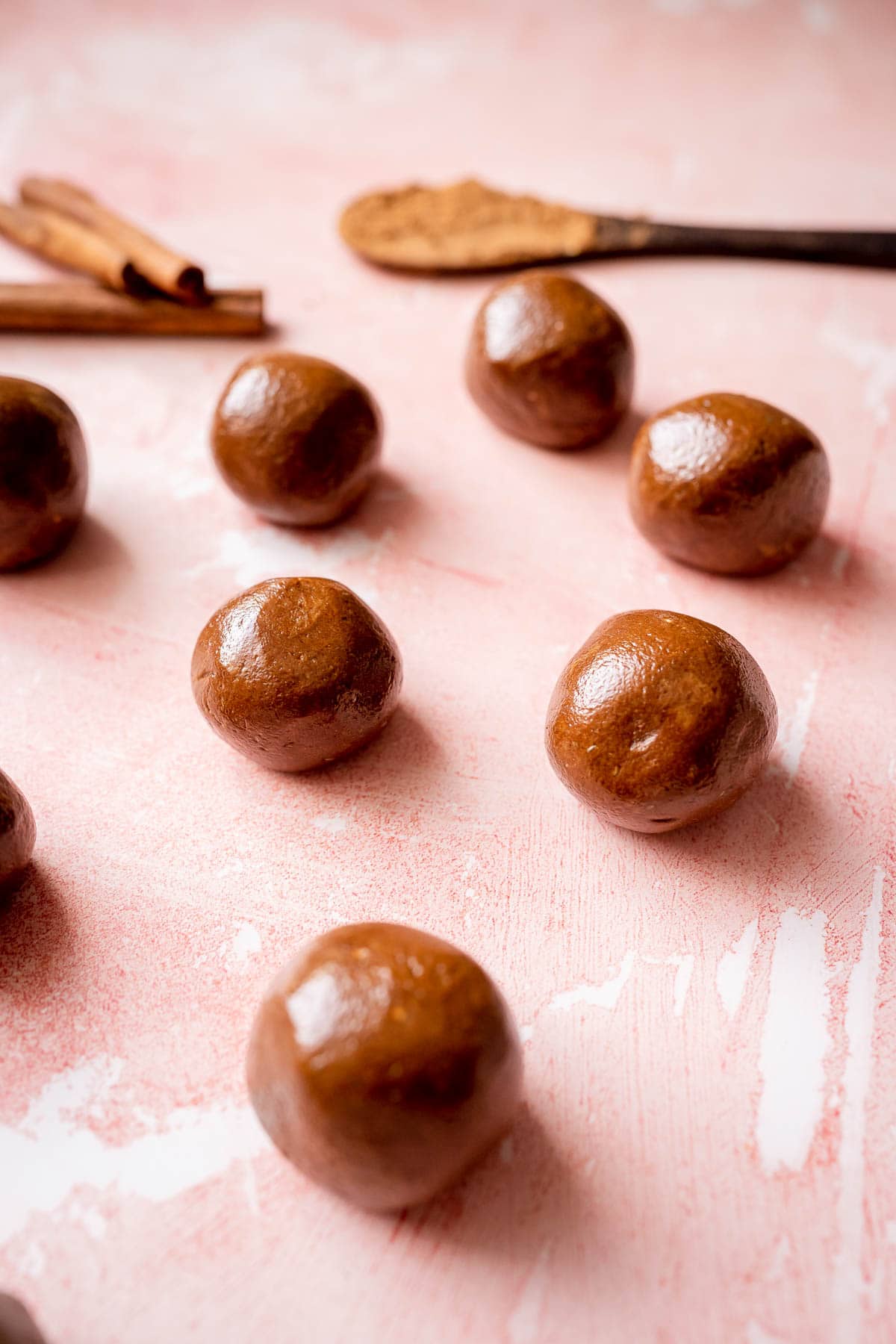 A close shot of chocolate sunflower balls resting on a pink surface.