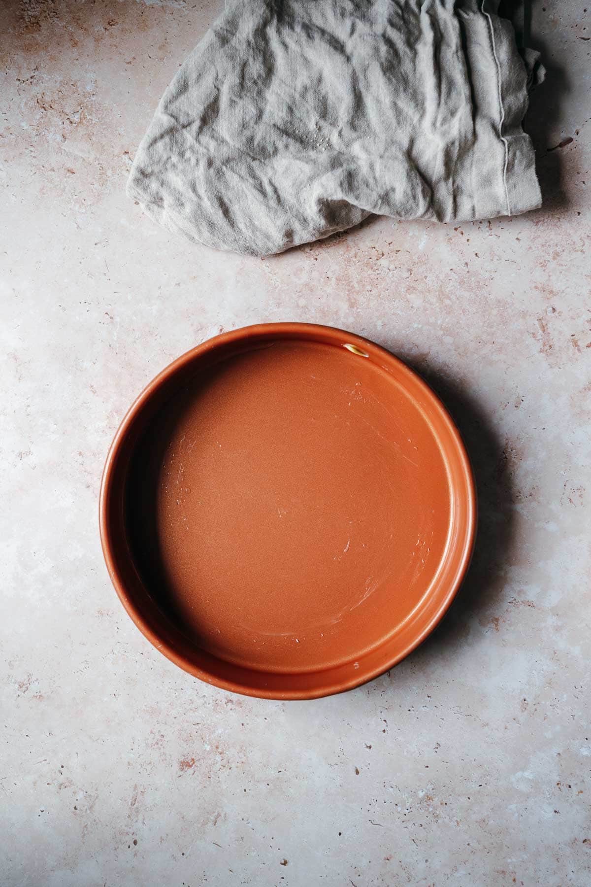 A round greased cake pan.