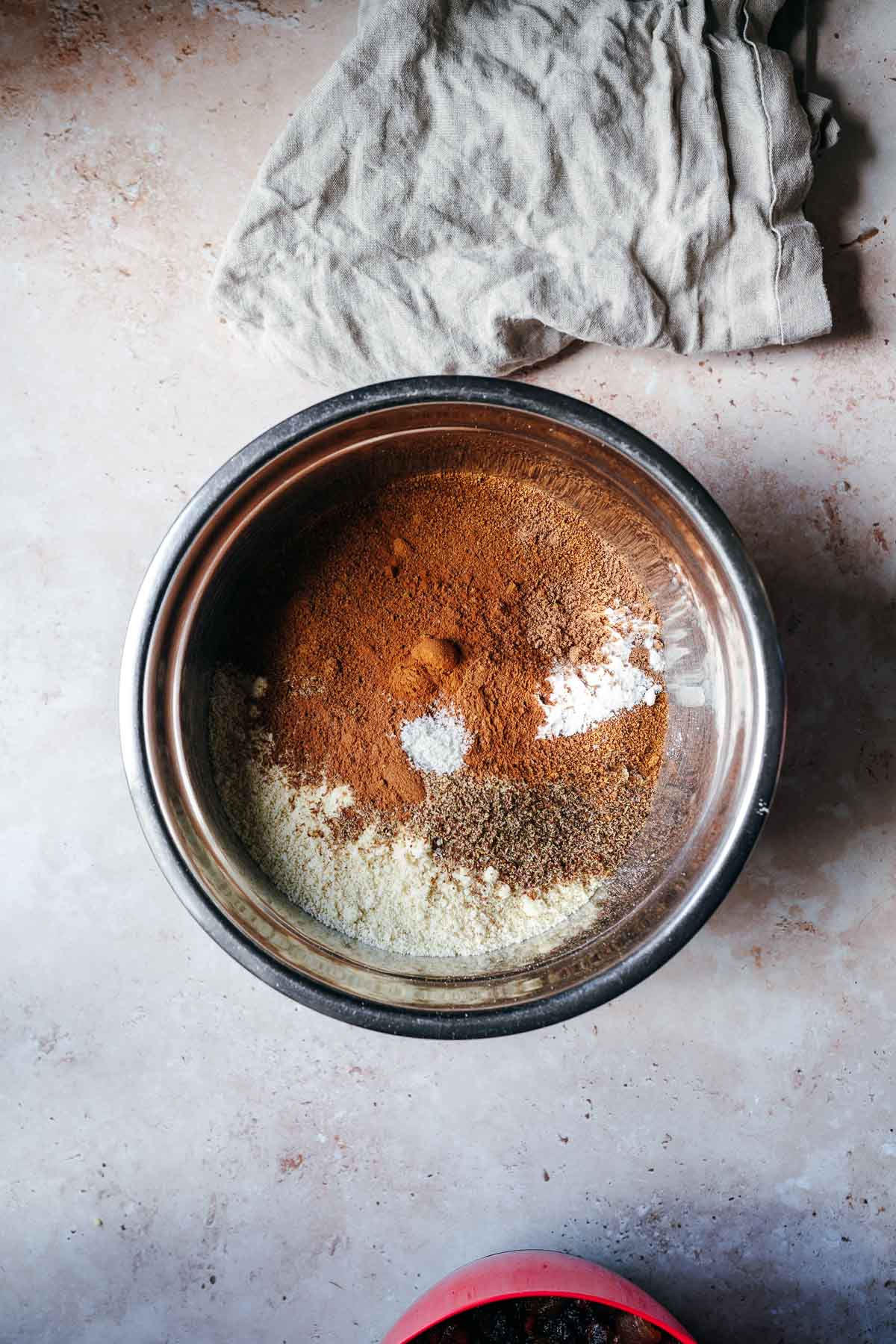 A silver mixing bowl filled with spices and flours.