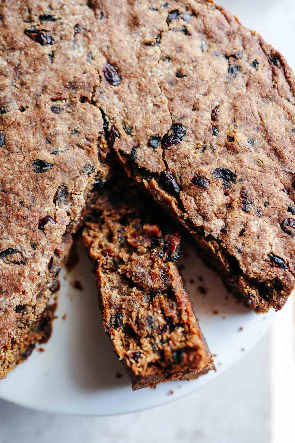 Top shot of a slice of fruit cake resting on its side displaying all the fruit.