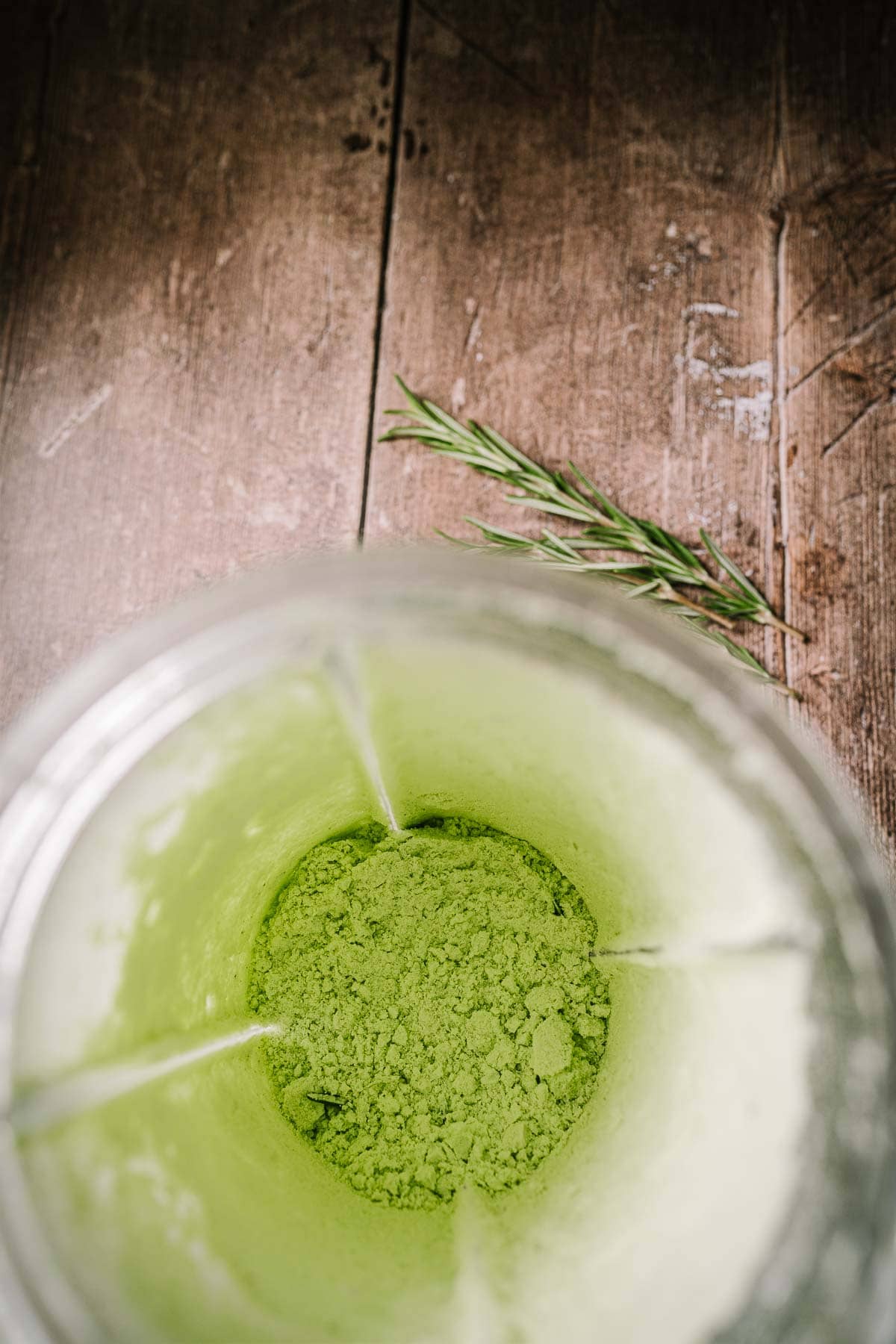 A blender container filled with a bright green salt.