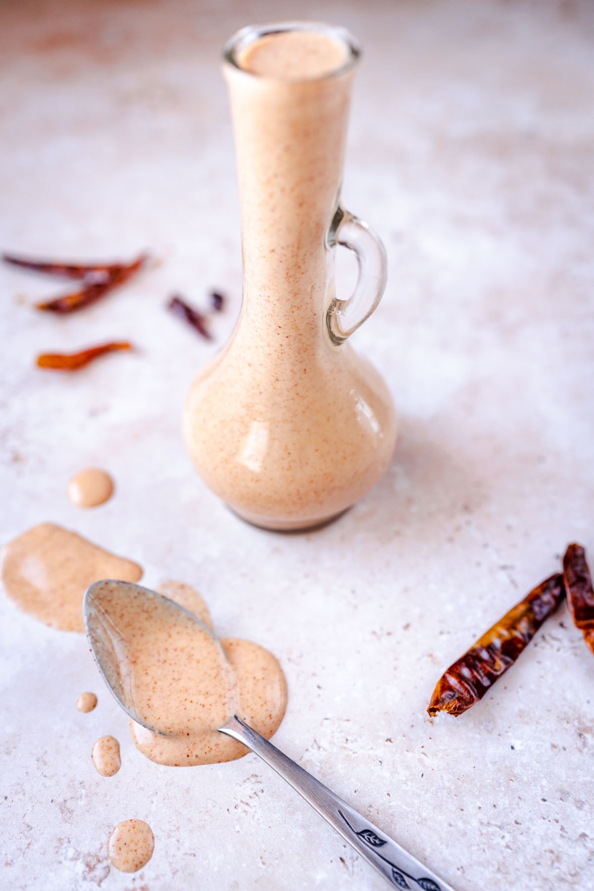 A clear glass salad dressing bottle filled with a light orange sauce.