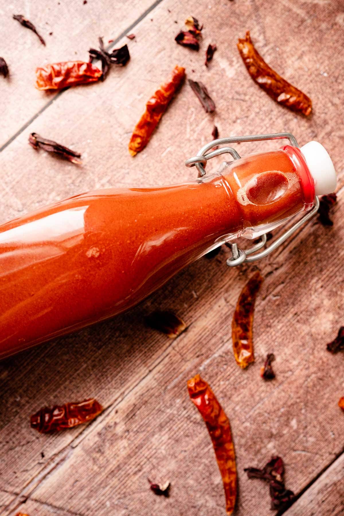 Close shot of a full glass bottle of red sauce.