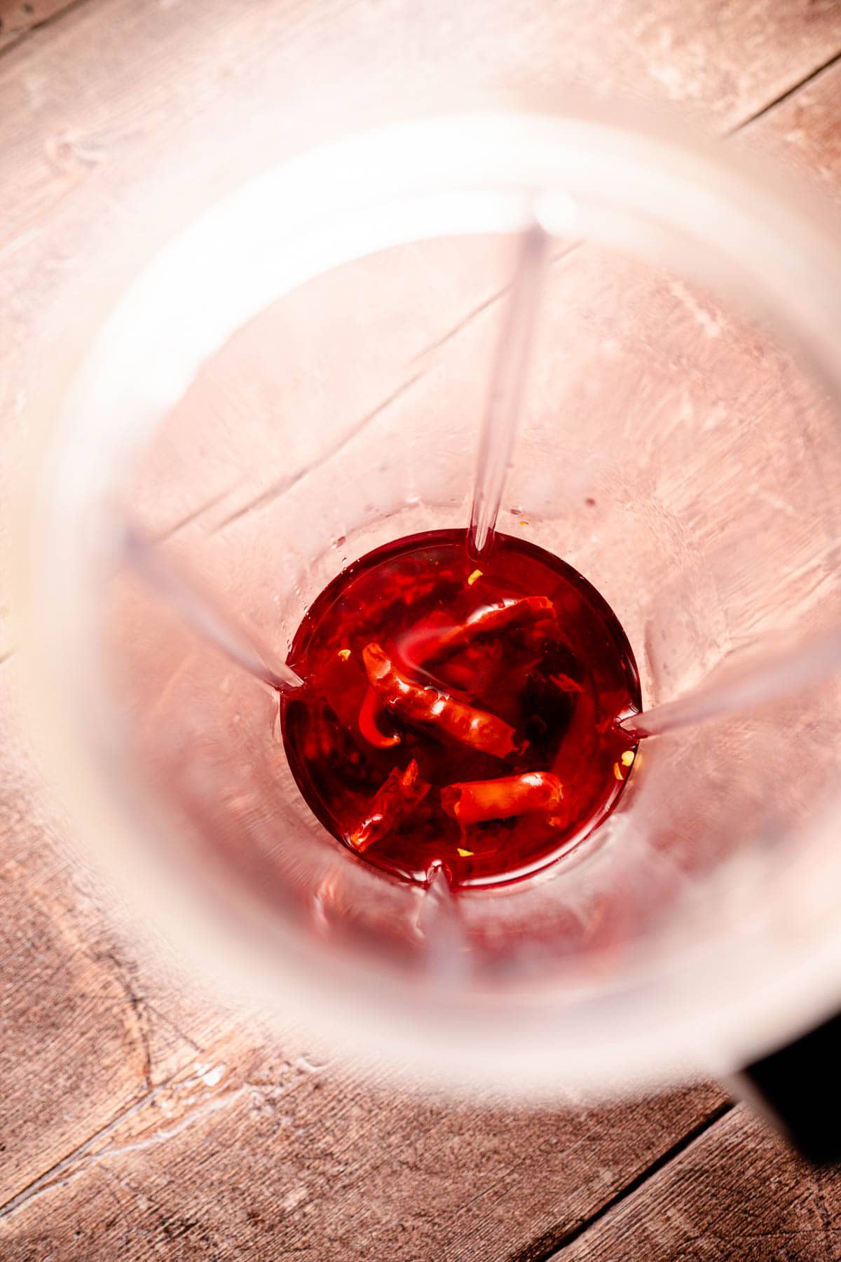 A blender canister filled with red ingredients.