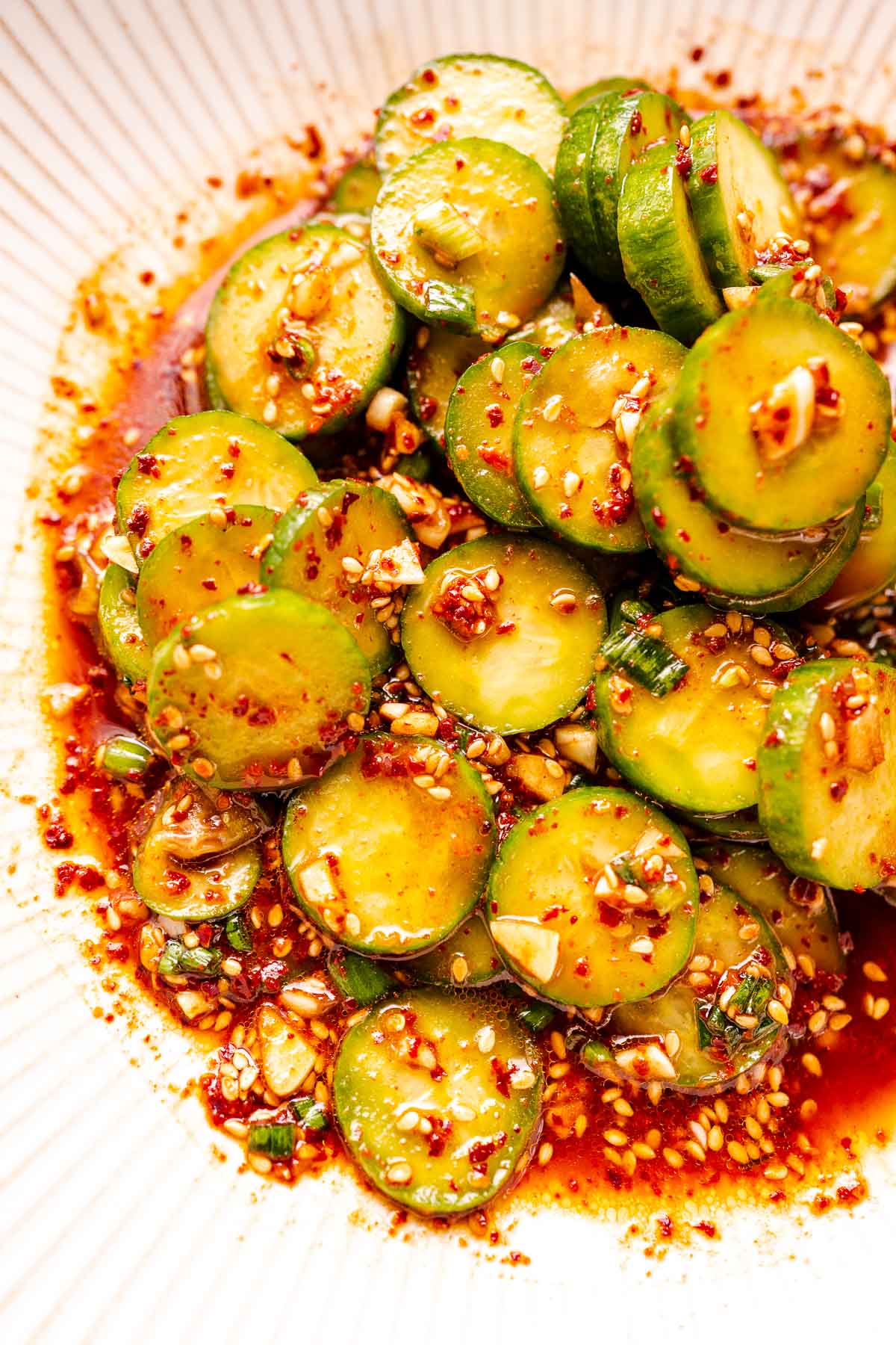 A close shot of Korean cucumber salad resting in a large white bowl.